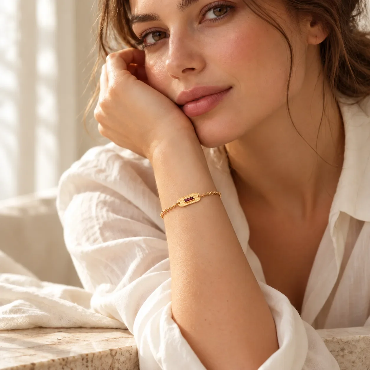 Woman wearing a 14K yellow gold hammered garnet bracelet