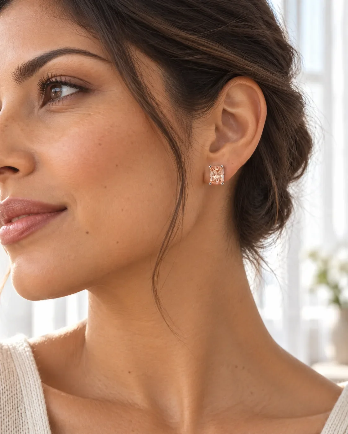 Peach zircon stud earrings worn on ear