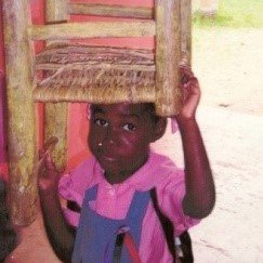 The boy with a chair on his head.