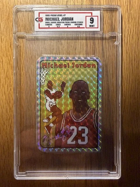 Holographic Michael Jordan trading card from 1995, featuring an illustration of Michael Jordan in a basketball uniform with the number 23, holding a basketball and about to shoot, enclosed in a protective plastic case.