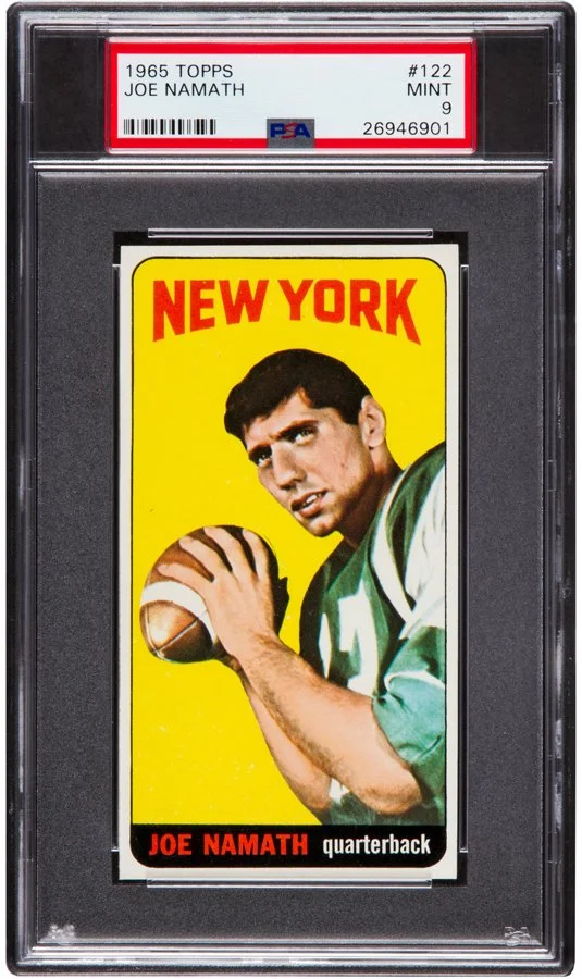 A 1965 Topps Joe Namath football trading card encased in a PSA graded slab. The card features a portrait of Joe Namath holding a football, with a yellow background and red text reading "NEW YORK" at the top. His name and position, quarterback, are printed at the bottom.