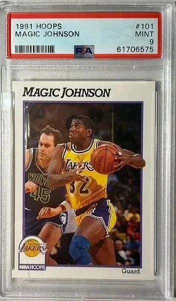 1991 NBA trading card of Magic Johnson in a protective case, graded Mint 9, featuring him playing basketball in a Lakers uniform.