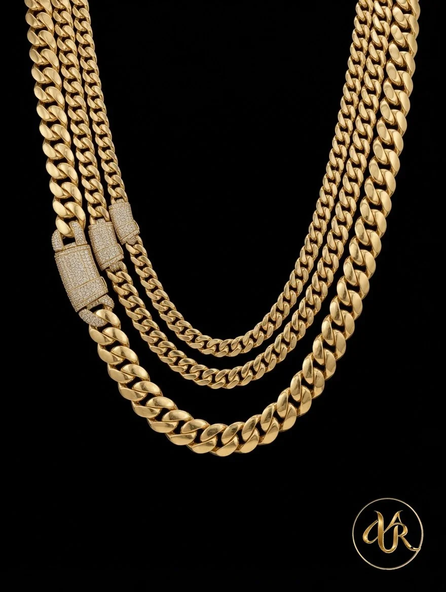 Three gold chain necklaces of varying thicknesses against a black background, with a small logo of intertwined initials 'AR' in the bottom right corner.
