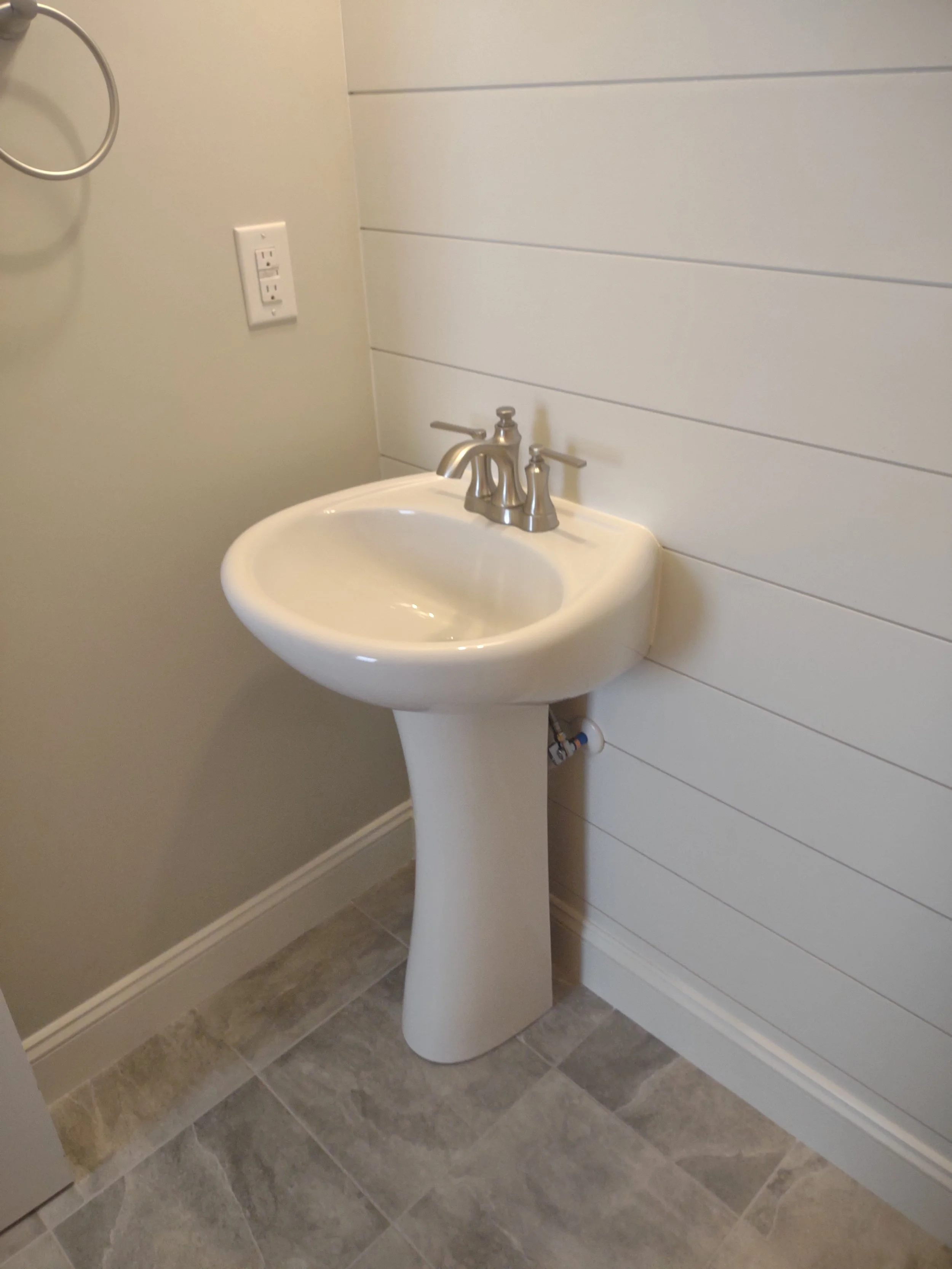 Half bath remodel with tile floor and shiplap accent wall