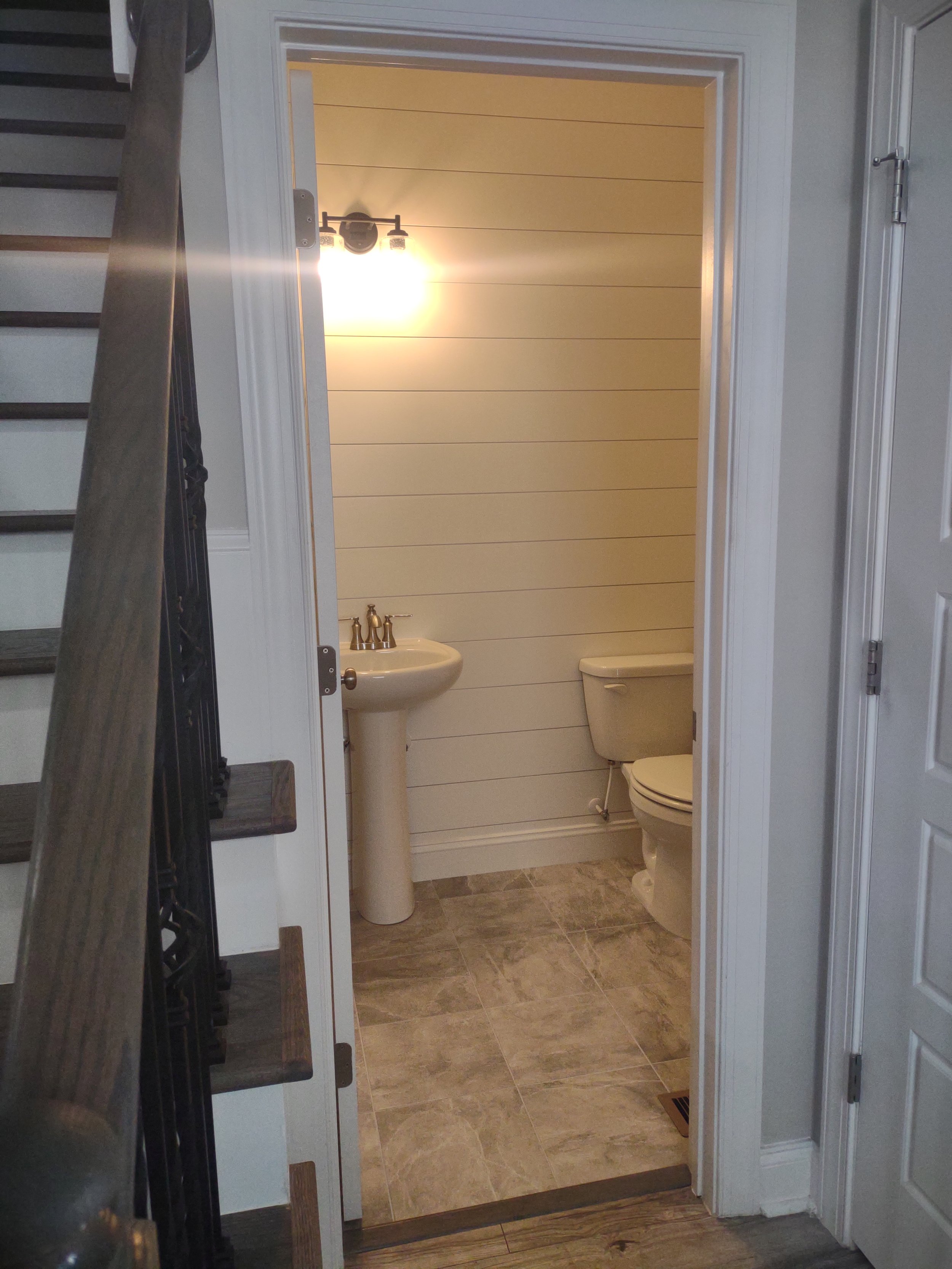Half bath remodel with tile floor and shiplap accent wall