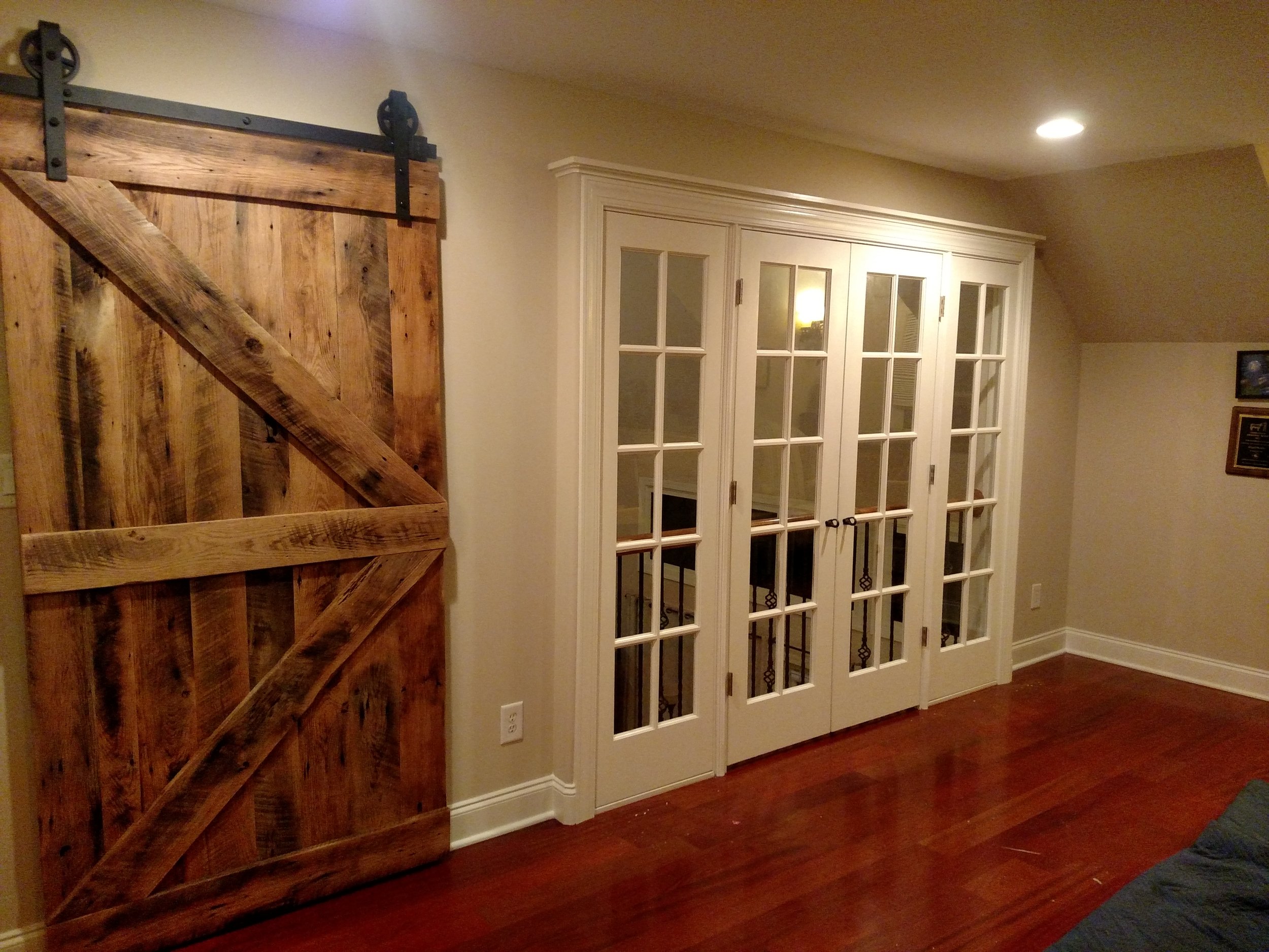 Custom 100+ year old barn wood used to create a custom heavy barn door and French door build out to promote privacy between floors