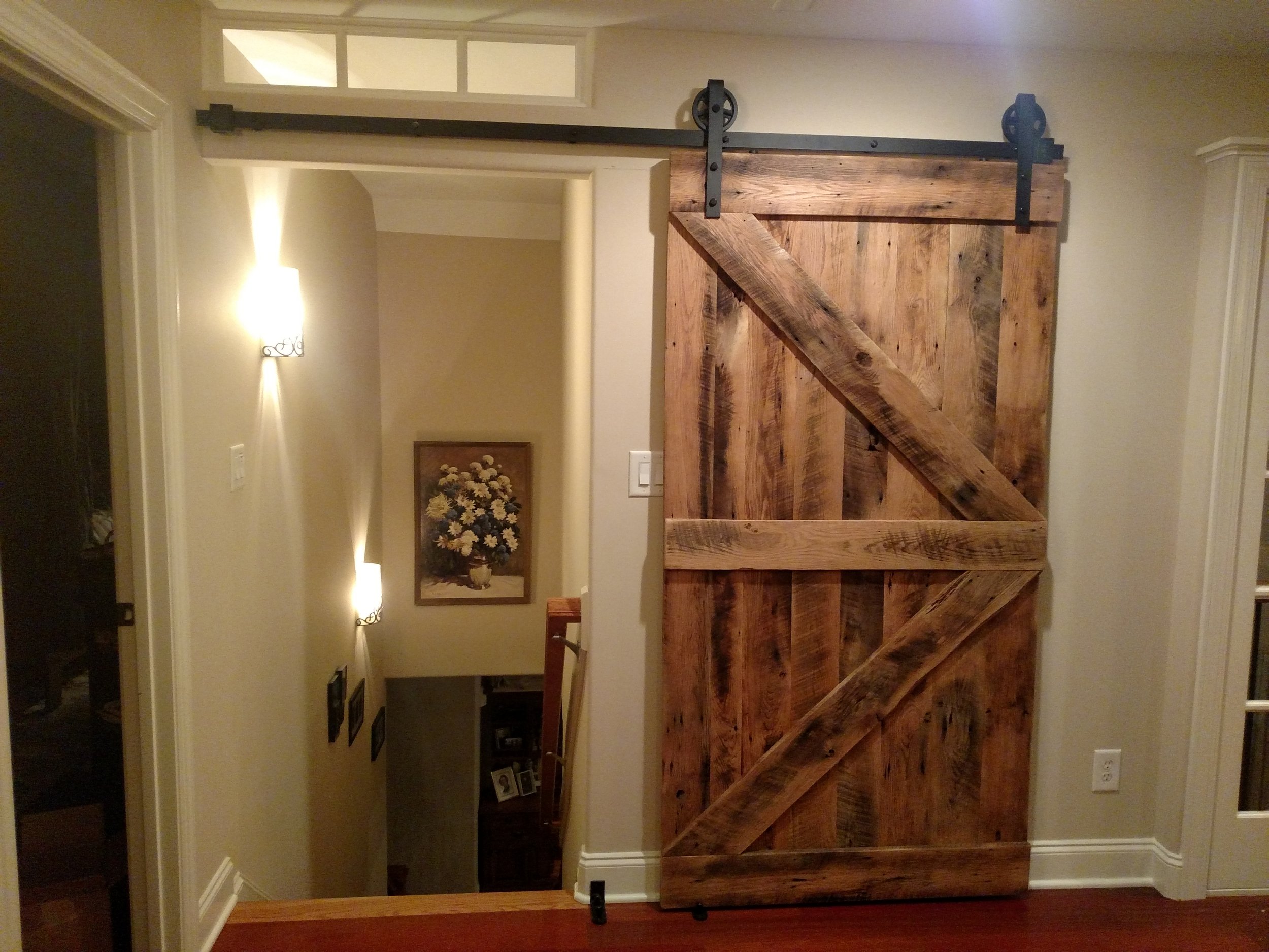 Custom 100+ year old barn wood used to create a custom heavy barn door and French door build out to promote privacy between floors
