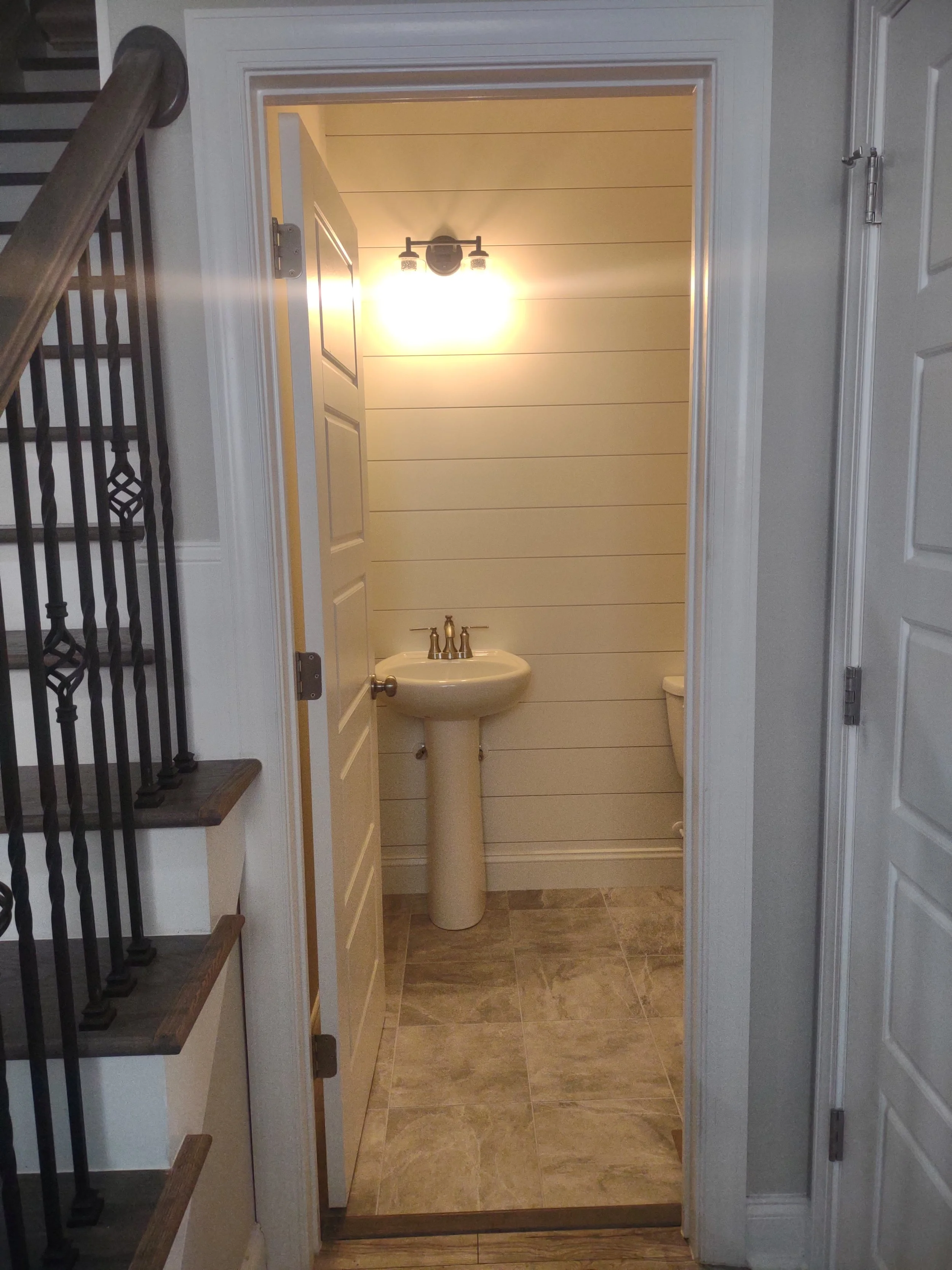 Half bath remodel with tile floor and shiplap accent wall