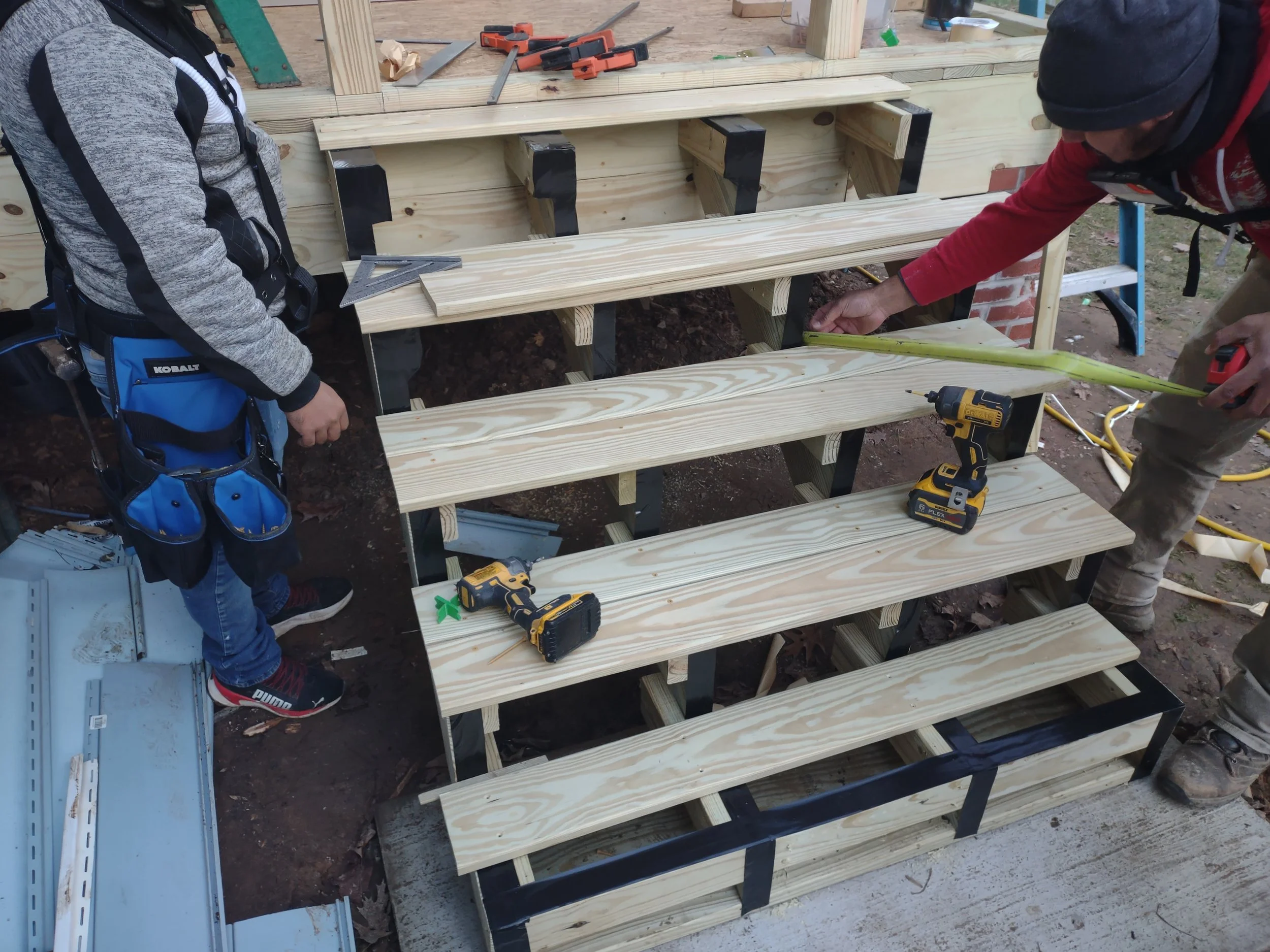 Important options for longevity are incorporated into the build. The step land on a concrete pad so they will last longer away from the soil and can drain. The joists have the black joist tape applied to protect the stringers and other supports from 