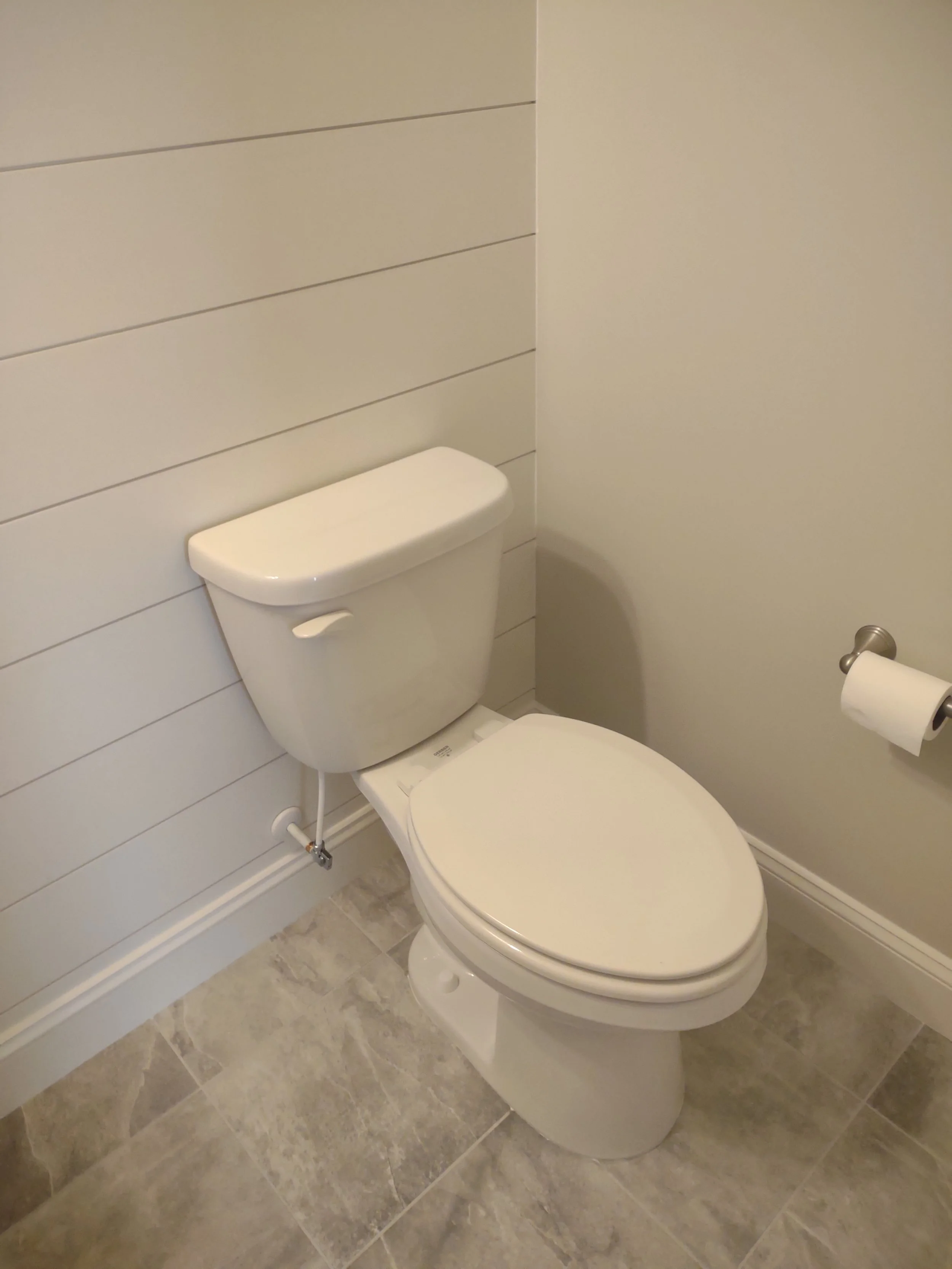 Half bath remodel with tile floor and shiplap accent wall