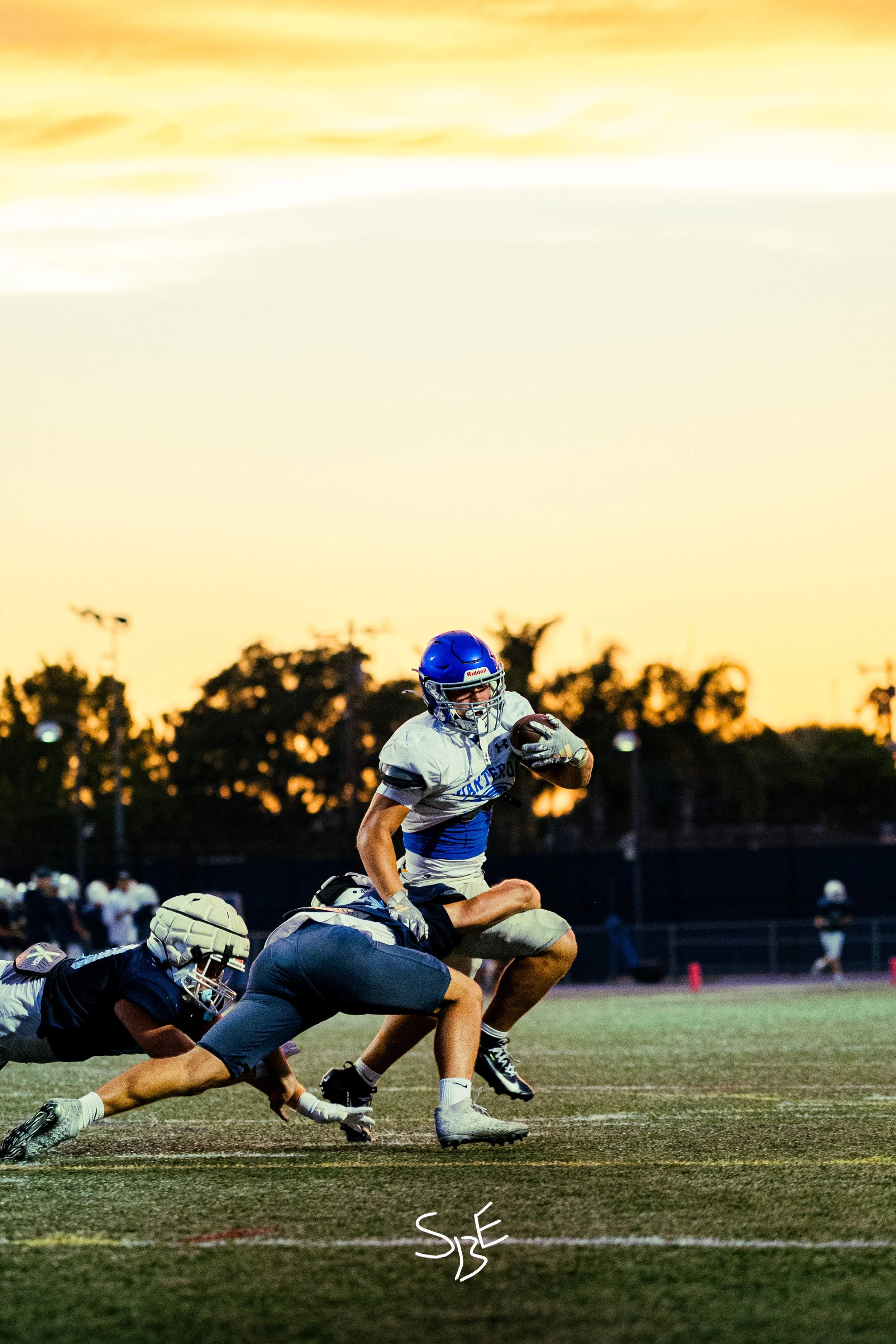 A football running back running into the endzone, pushing down and getting past defenders to score for Charter Oak