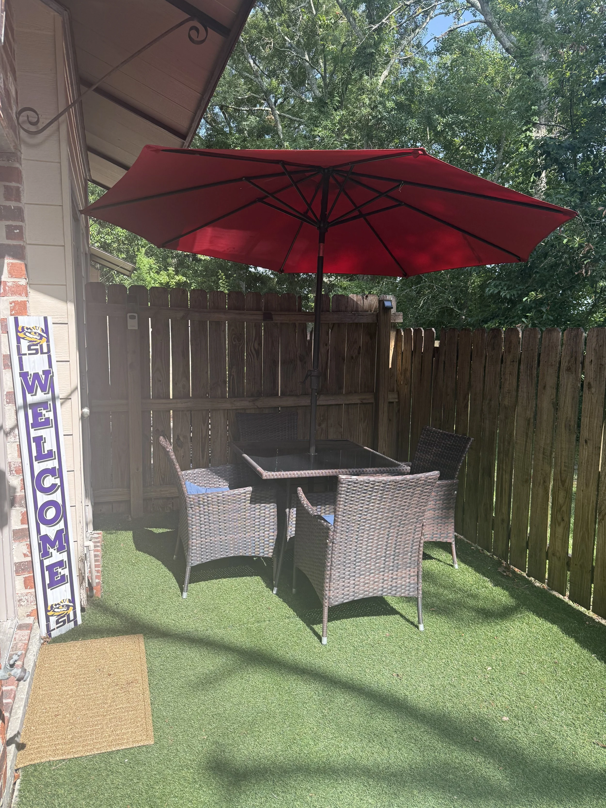 Enjoy outdoor dining while staying at your Baton Rouge townhouse rental close to LSU campus.  The back patio includes a 4 person dining table with an umbrella and two comfortable outdoor club chairs.  