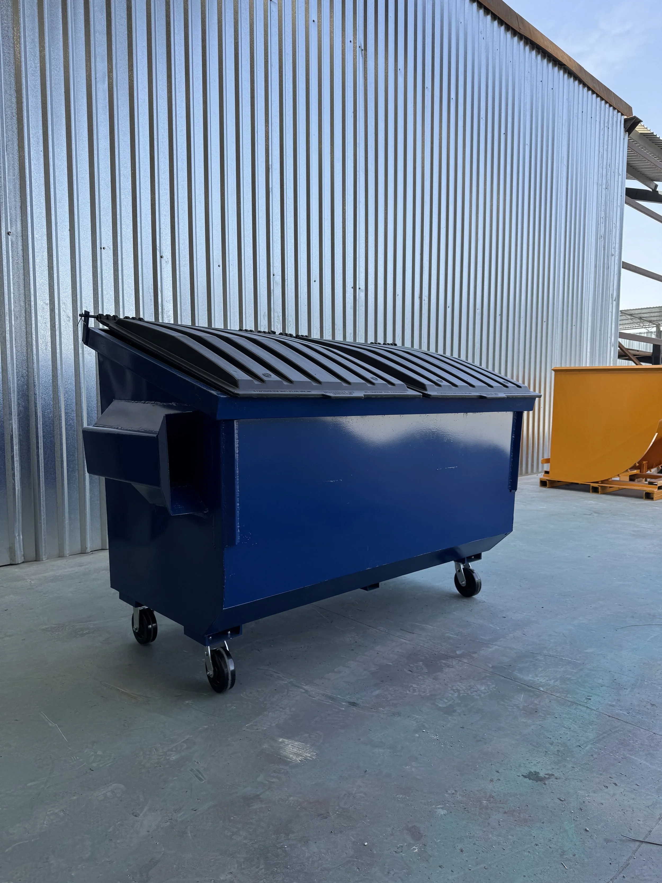 WASTE MANAGEMENT DUMPSTER WITH A CAPACITY OF 2 YARDS WITH PLASTIC LIDS AND PLASTIC WHEELS.