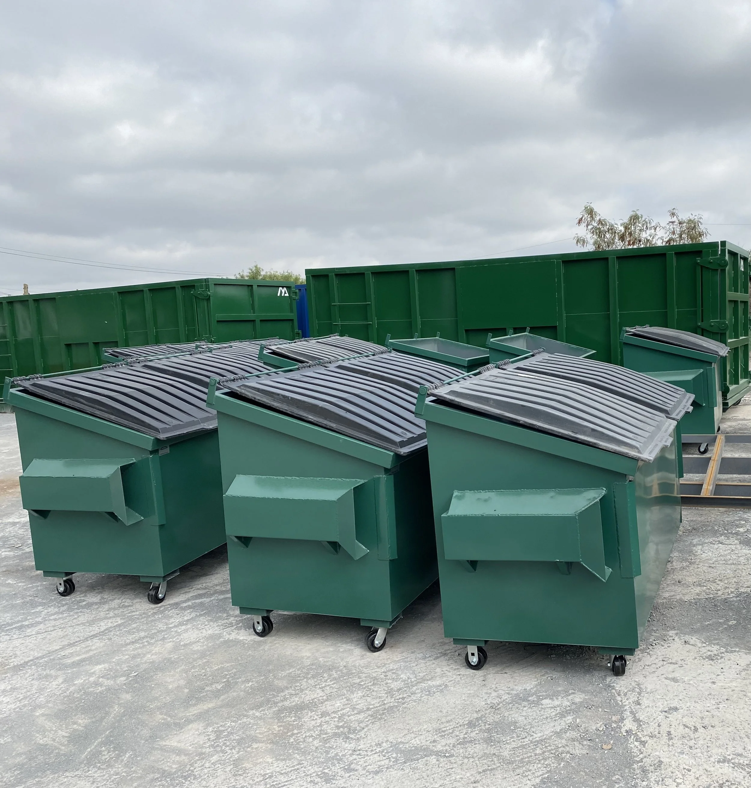 FRONT LOAD DUMPSTERS WITH PLASTIC LIDS FOR WASTE MANAGEMENT.