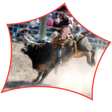 A person riding a bucking bull at a rodeo event, with a crowd watching in the background.