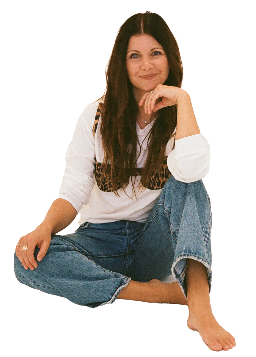 Allison Blackwell sitting barefoot in jeans and a white shirt