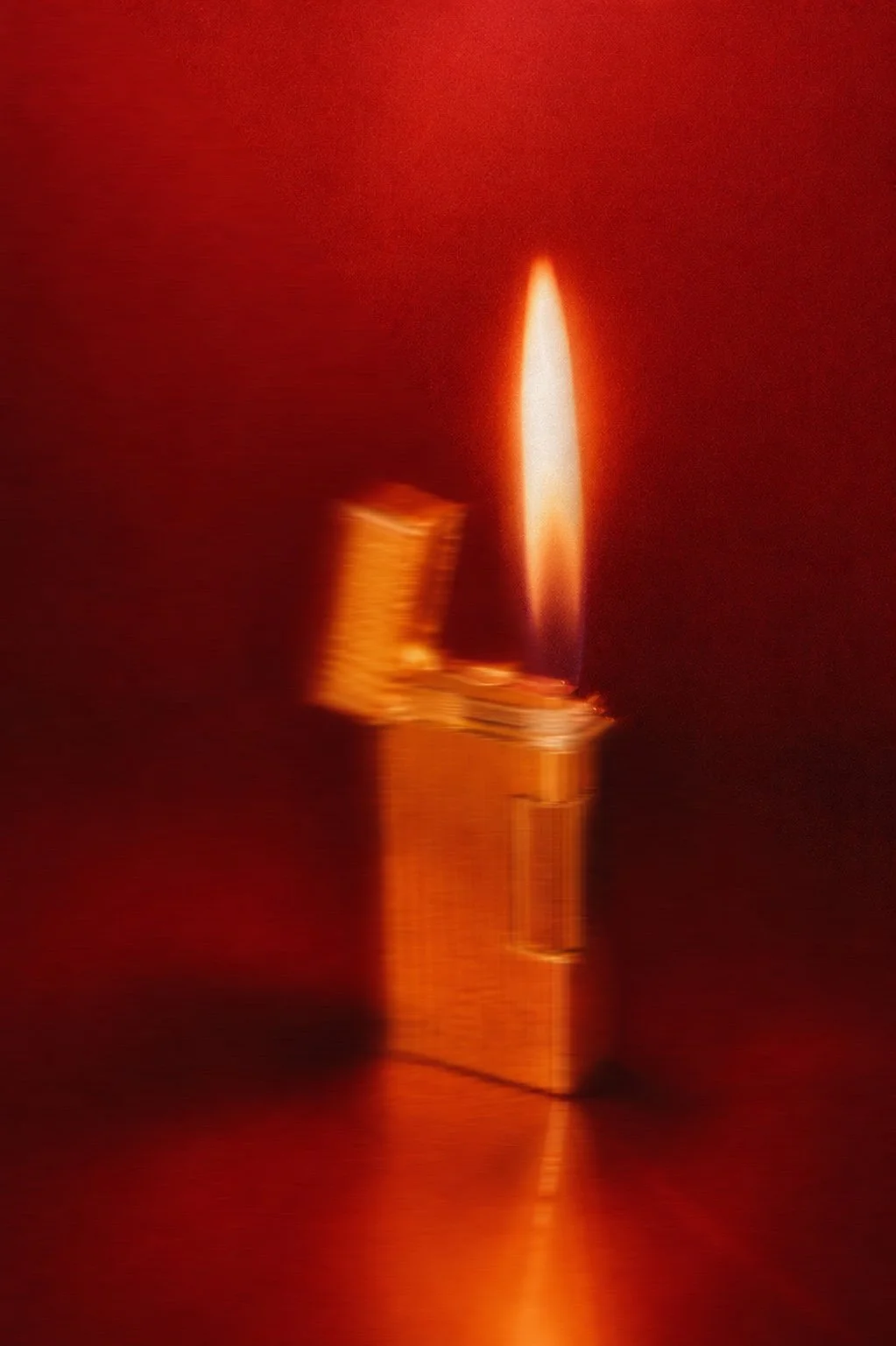 Close-up of a lit lighter against a red background