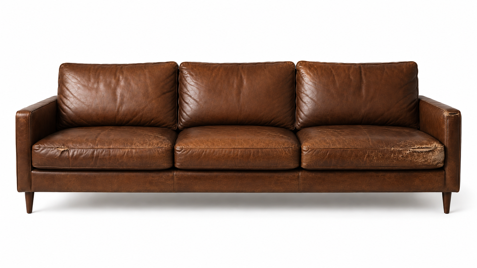 A vintage brown leather sofa with three cushions, showing signs of wear and tear, set against a plain white background.
