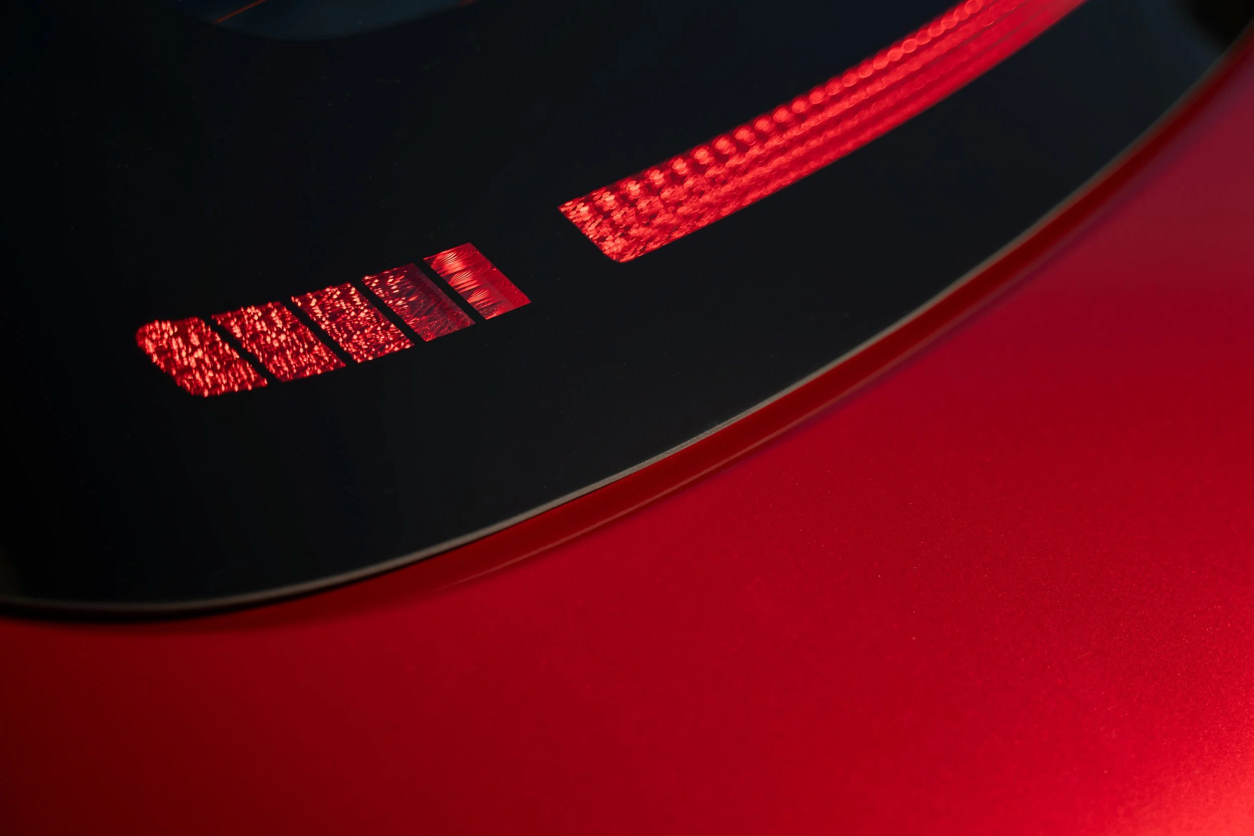 Close-up of a red and black textured surface with geometric patterns and lighting.