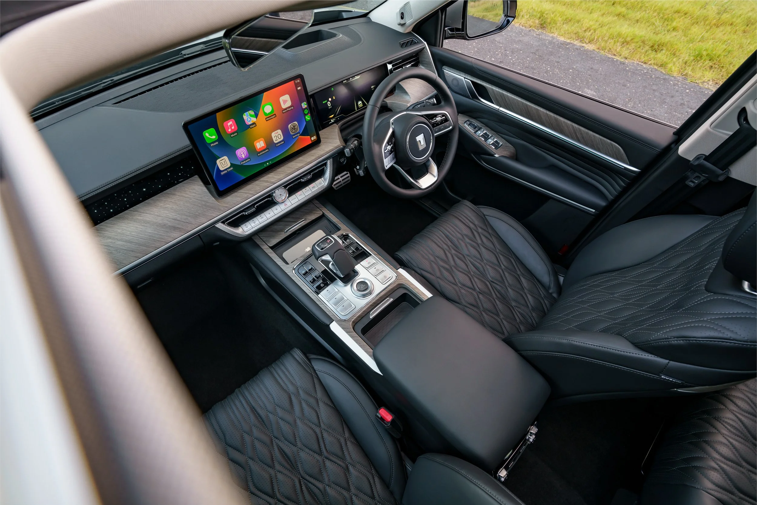 Interior of a modern vehicle showing a large digital dashboard, steering wheel, center console with gear shifter, and a mounted touchscreen display.