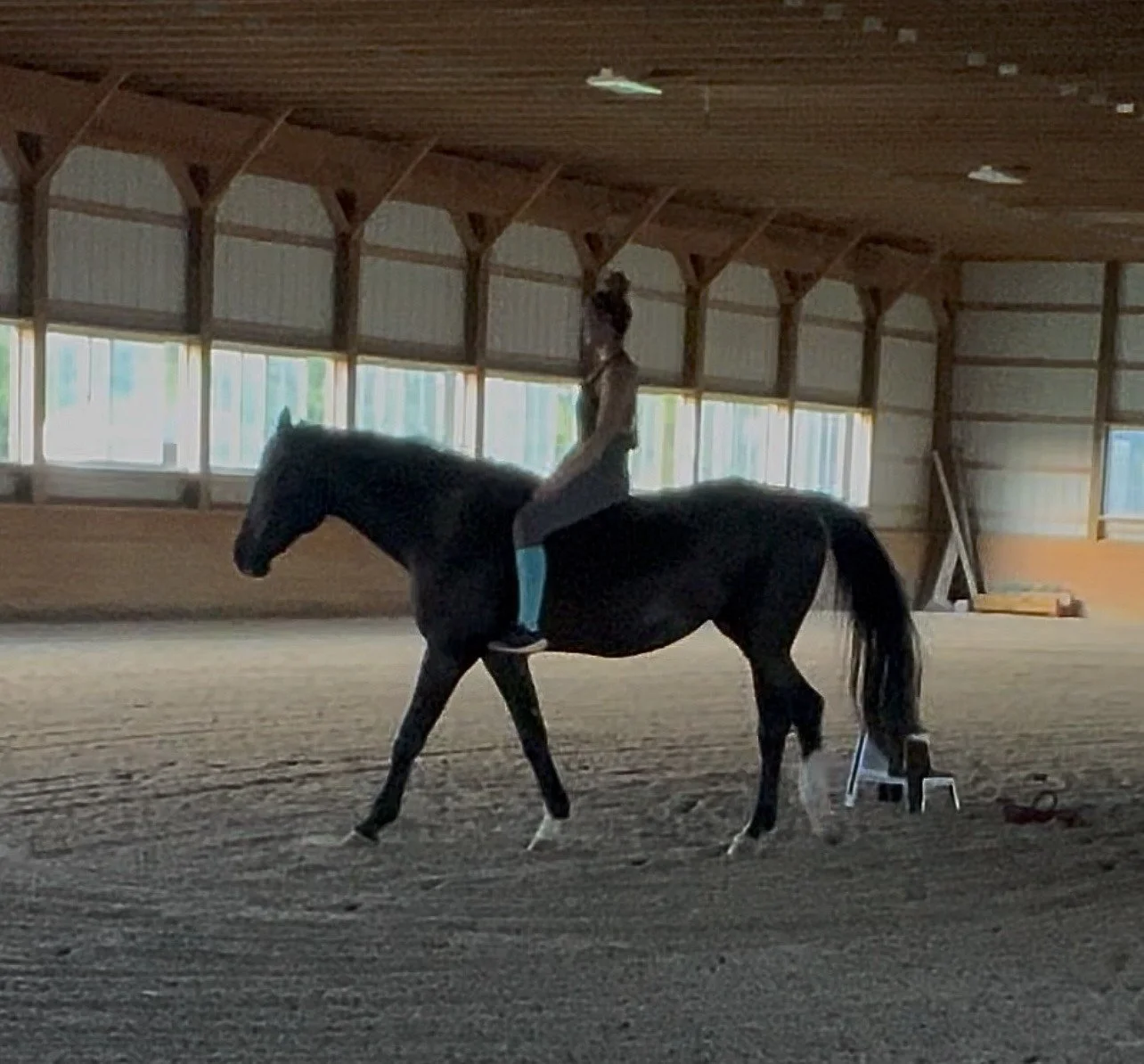 A therapist riding her horse bareback in an indoor arena, illustrating how trust, relationship, and nervous system regulation can create safety beyond appearances. This image accompanies a discussion on trauma recovery, and equine-connected EMDR.