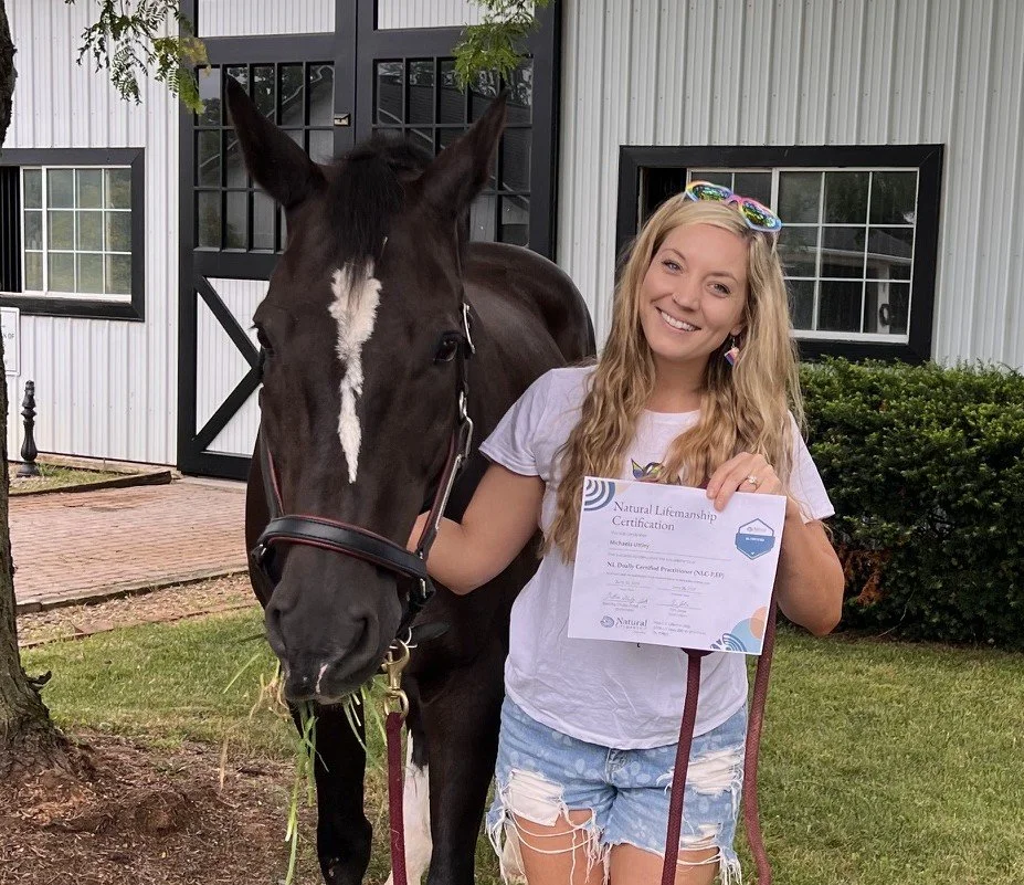 Therapist standing with her horse Nora while holding her Natural Lifemanship certification, reflecting her commitment to equine-assisted trauma therapy.
