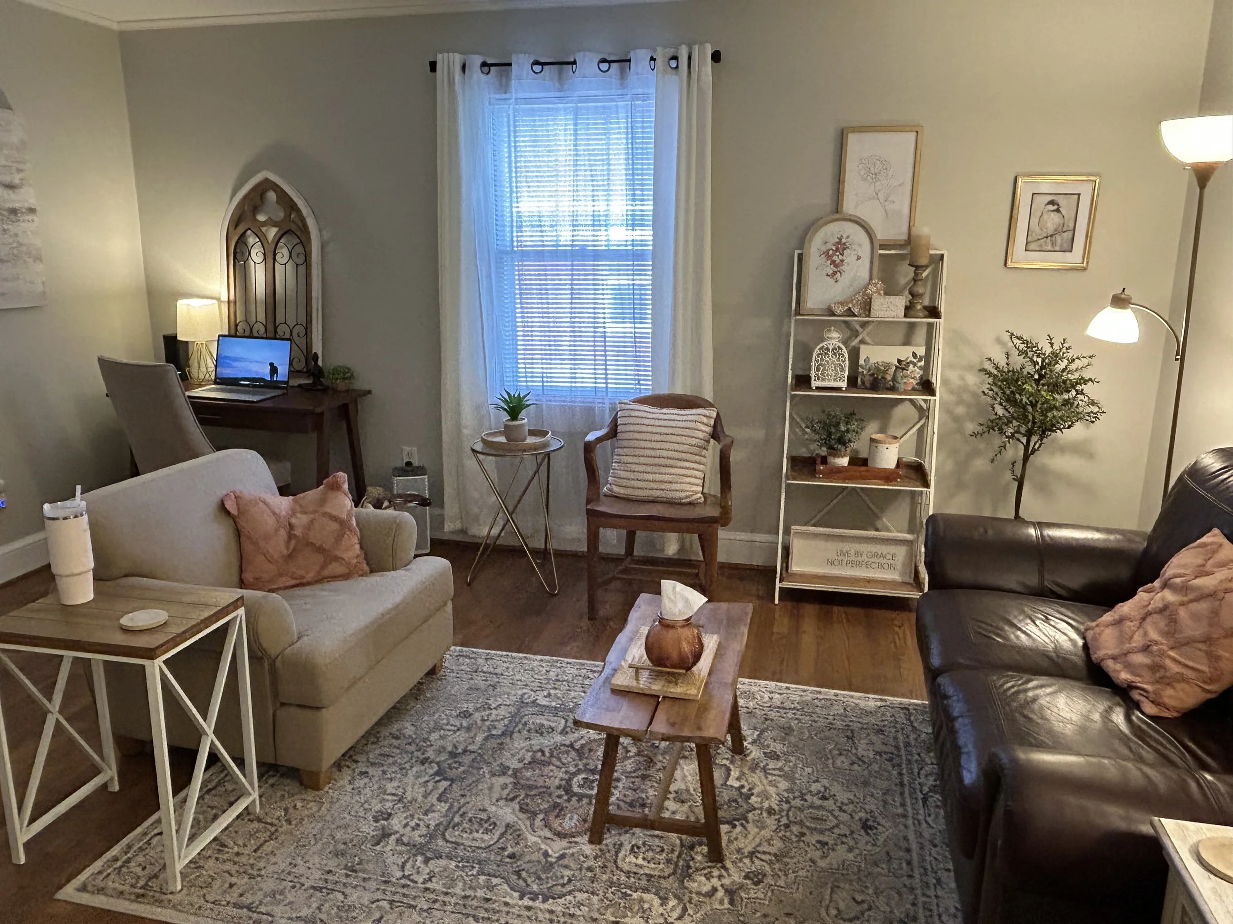 A cozy office space to conduct therapy, with plush seating, warm lights, and greenery