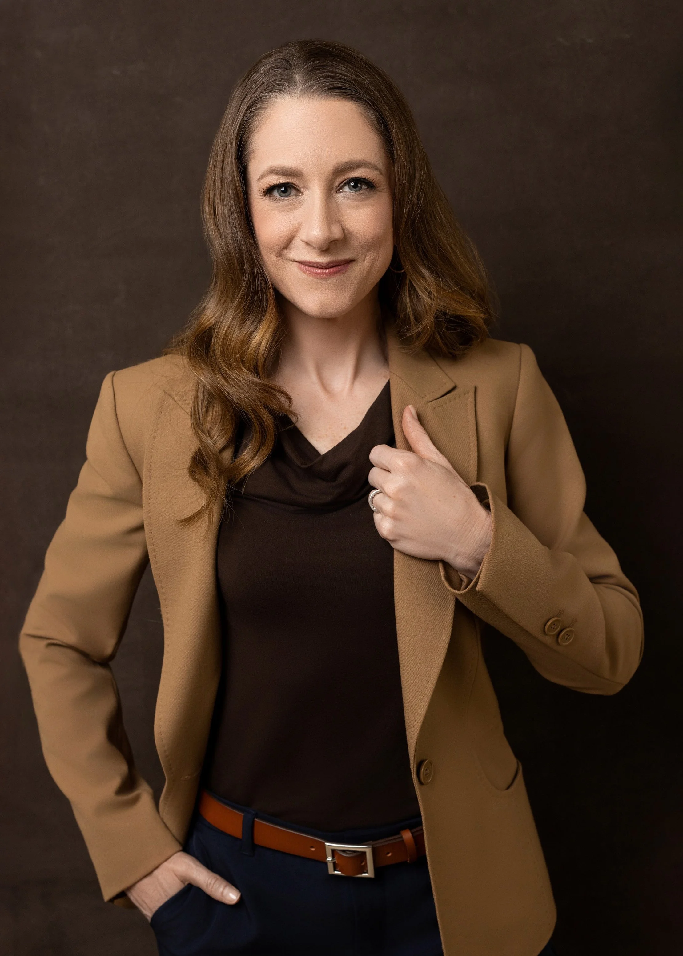 Closer professional headshot photographed against a warm brown background.