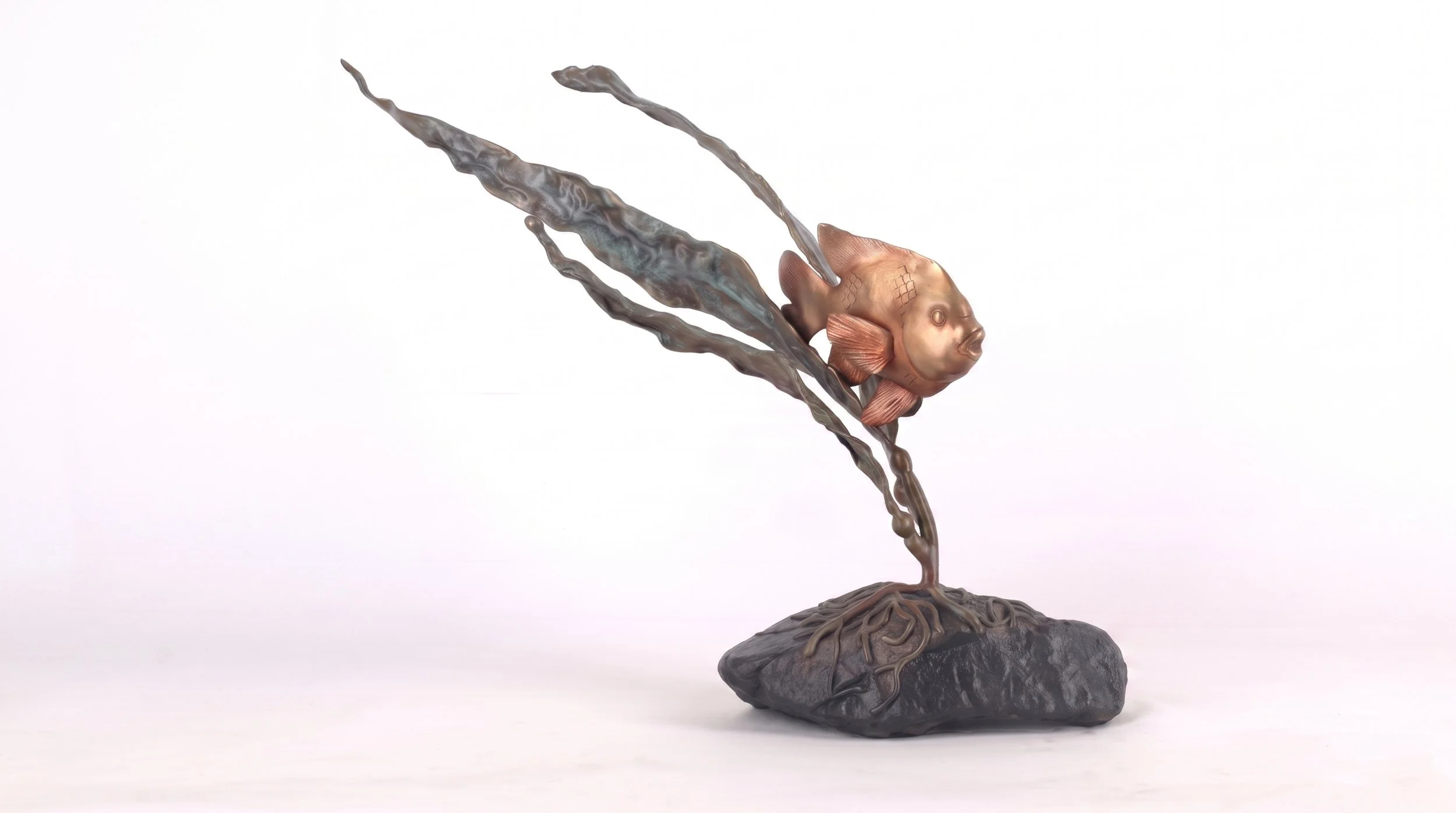A sculpture of a Garibaldi fish with a body made of bronze, flying above a rock with roots or tendrils swirling around it. By Judy Salinsky