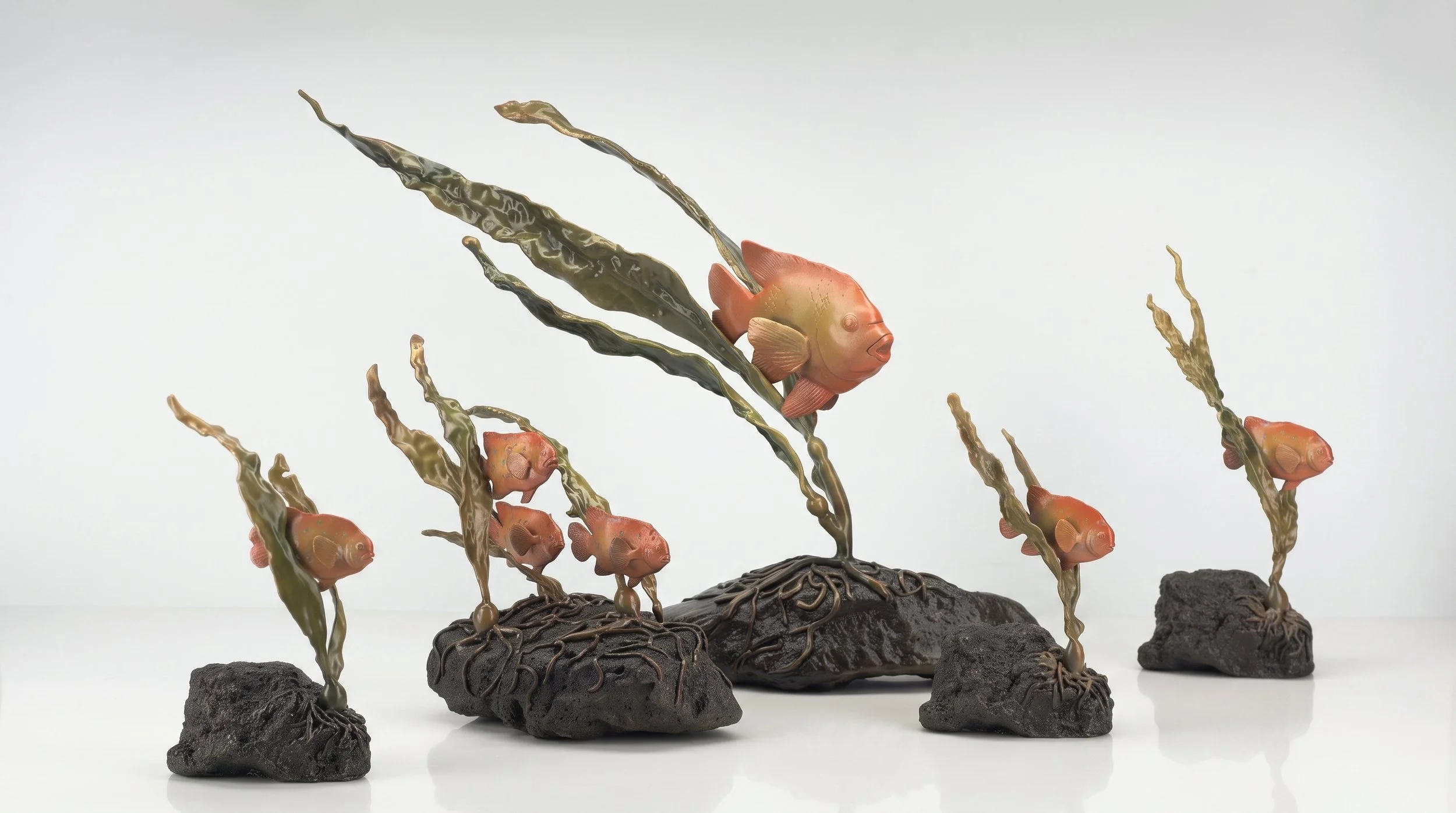 Artistic sculpture of the Garibaldi family swimming among aquatic plants on volcanic rock bases. by Judy Salinsky