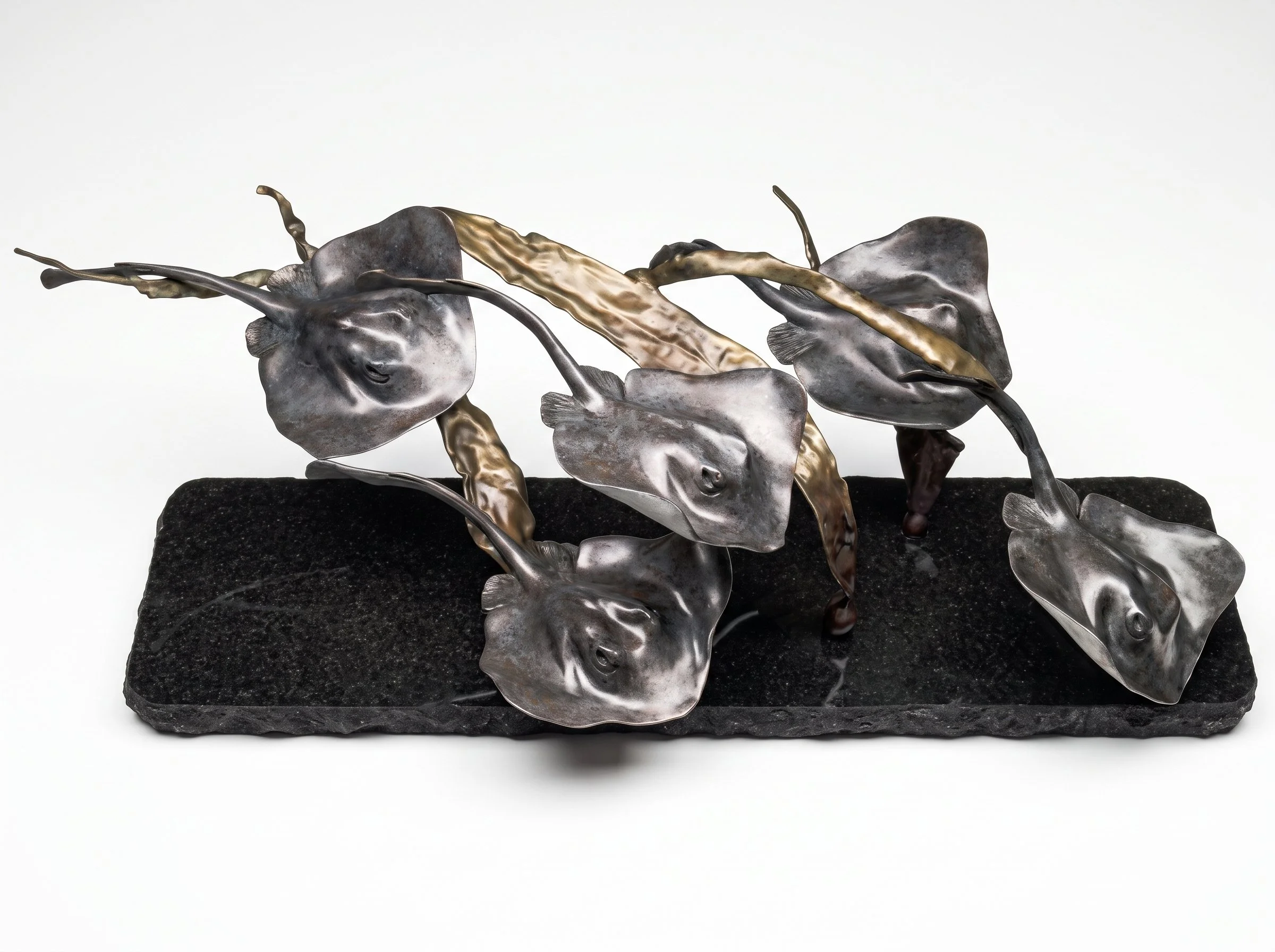 Bronze sculpture of 5 stingrays flowing together called "The Fever". By Judy Salinsky
