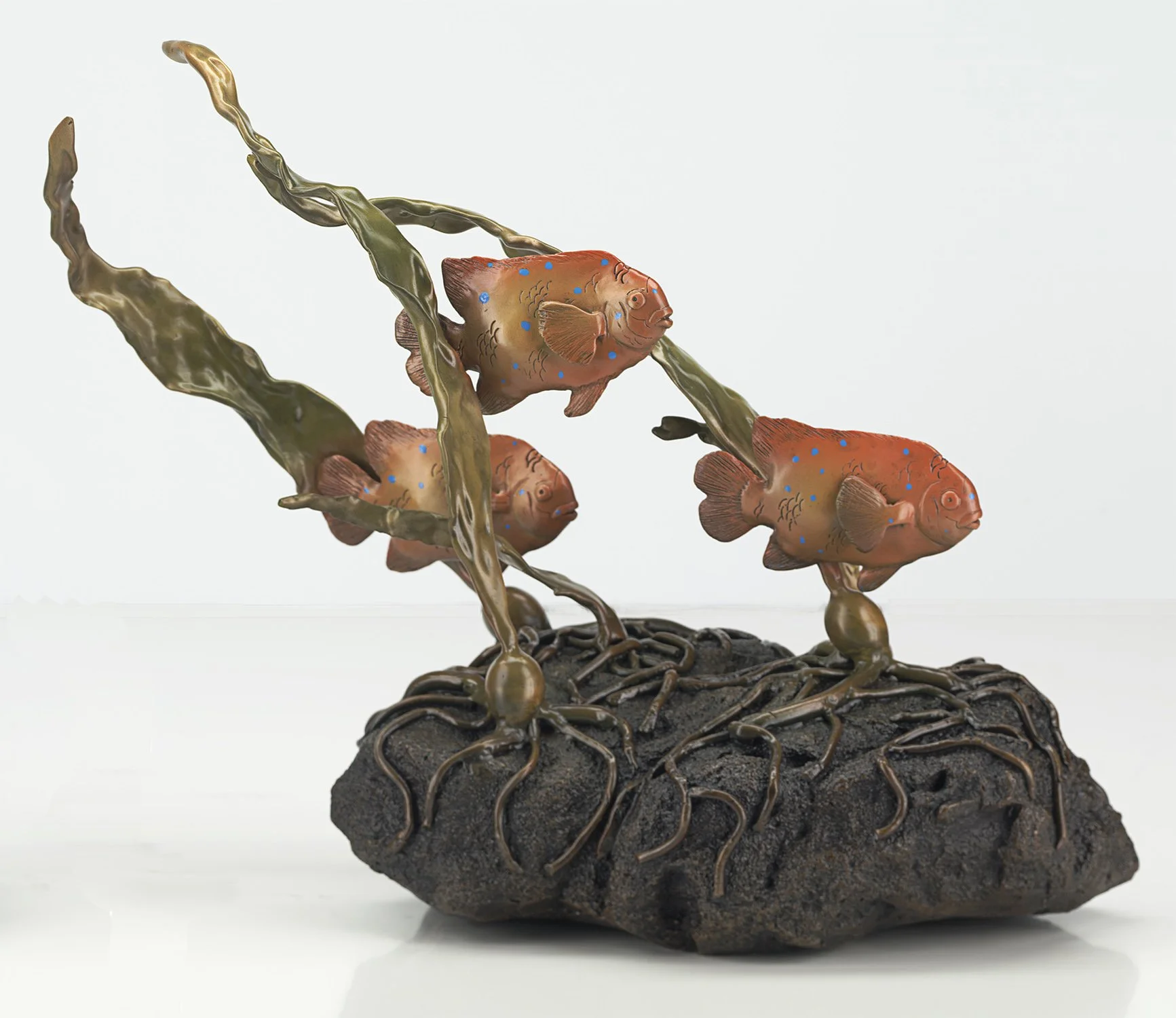 Baby Garibaldi represents the juvenile Garibaldi (California State Fish) with blue spots.
Each piece is crafted with genuine kelp mold to lend it a distinctive quality. Sculpture of three Garibaldi fish by Judy Salinsky.