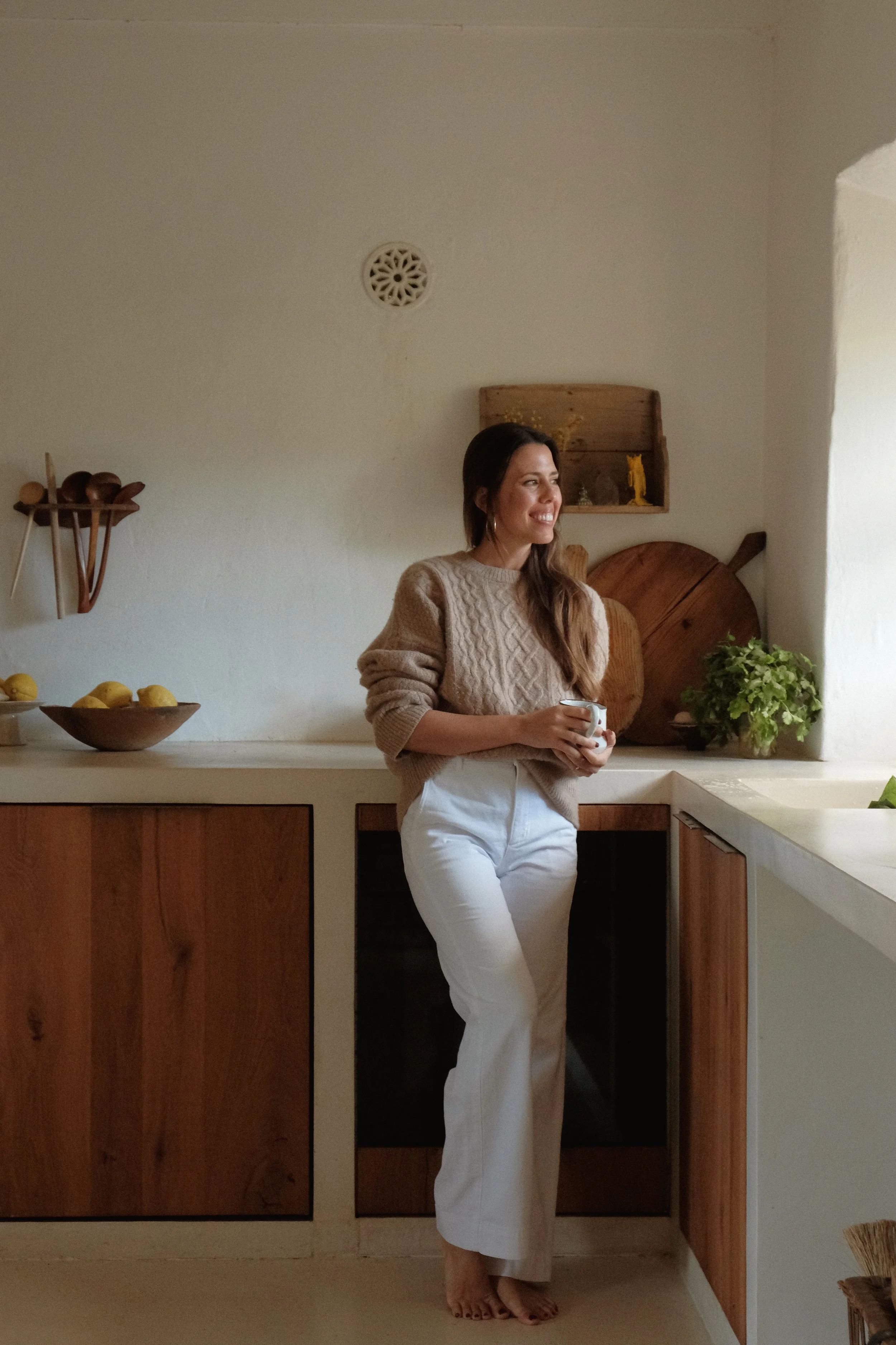 Claire standing in her kitchen holding a mug