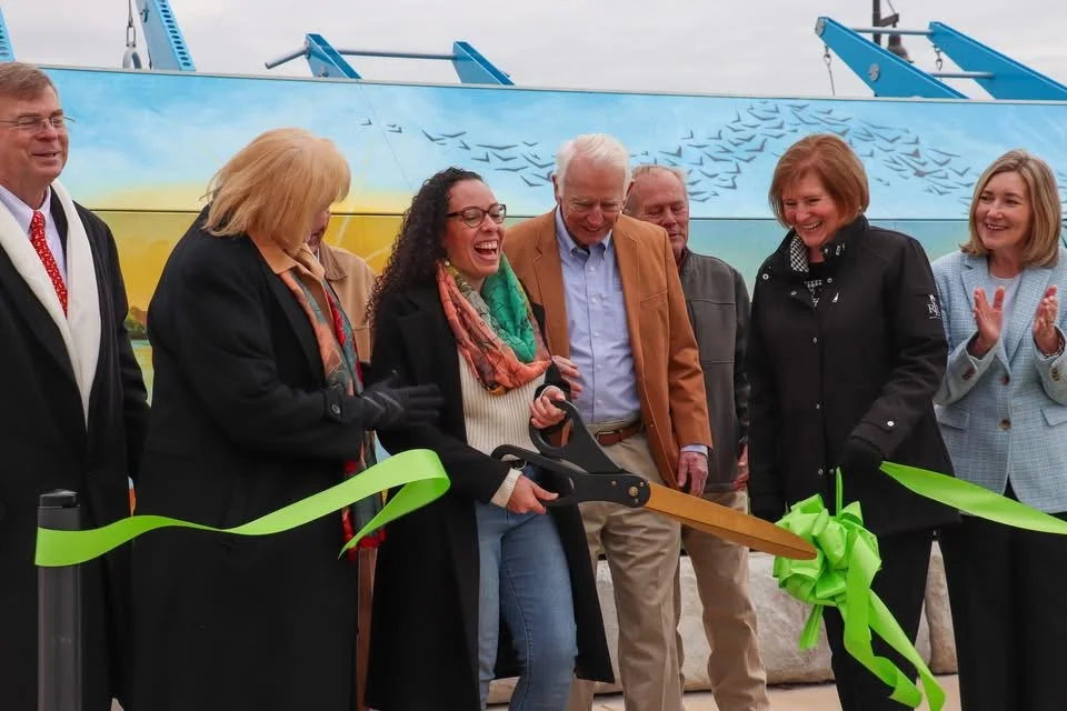Corinna Nicole of Huntsville, AL, cuts the ribbon at the opening of the Hays Farm Park outdoor fitness court featuring her mural.