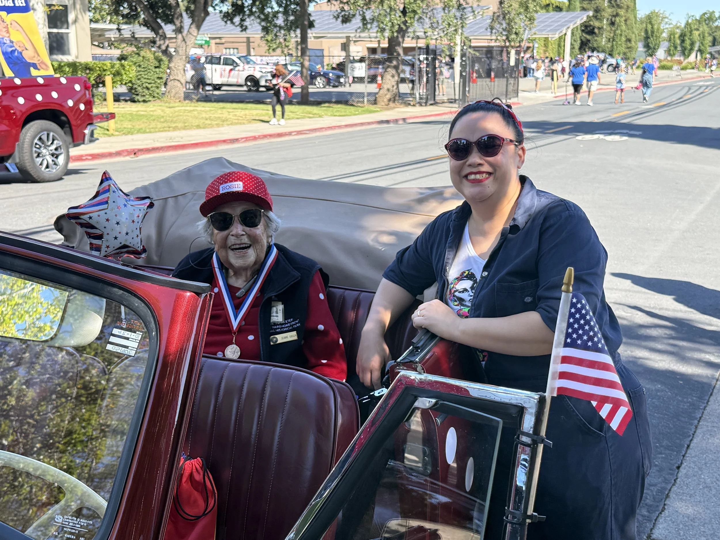 Christy with a car and Jeanne, an original Rosie from WWII days, as part of the Rosie the Riveter portion of the parade in Concord