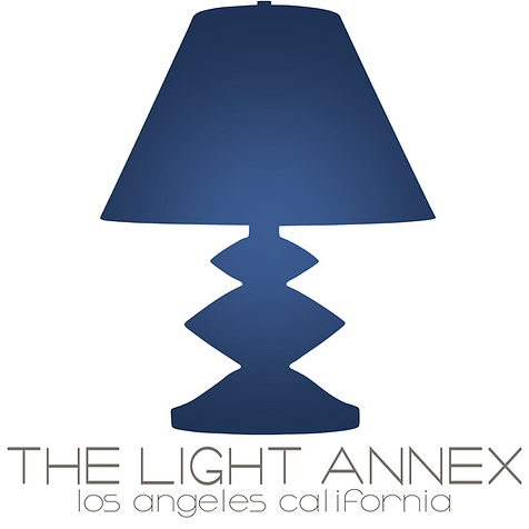 A dark blue table lamp with a geometric base and a matching lampshade, with text below reading 'The Light Annex, Los Angeles, California'.