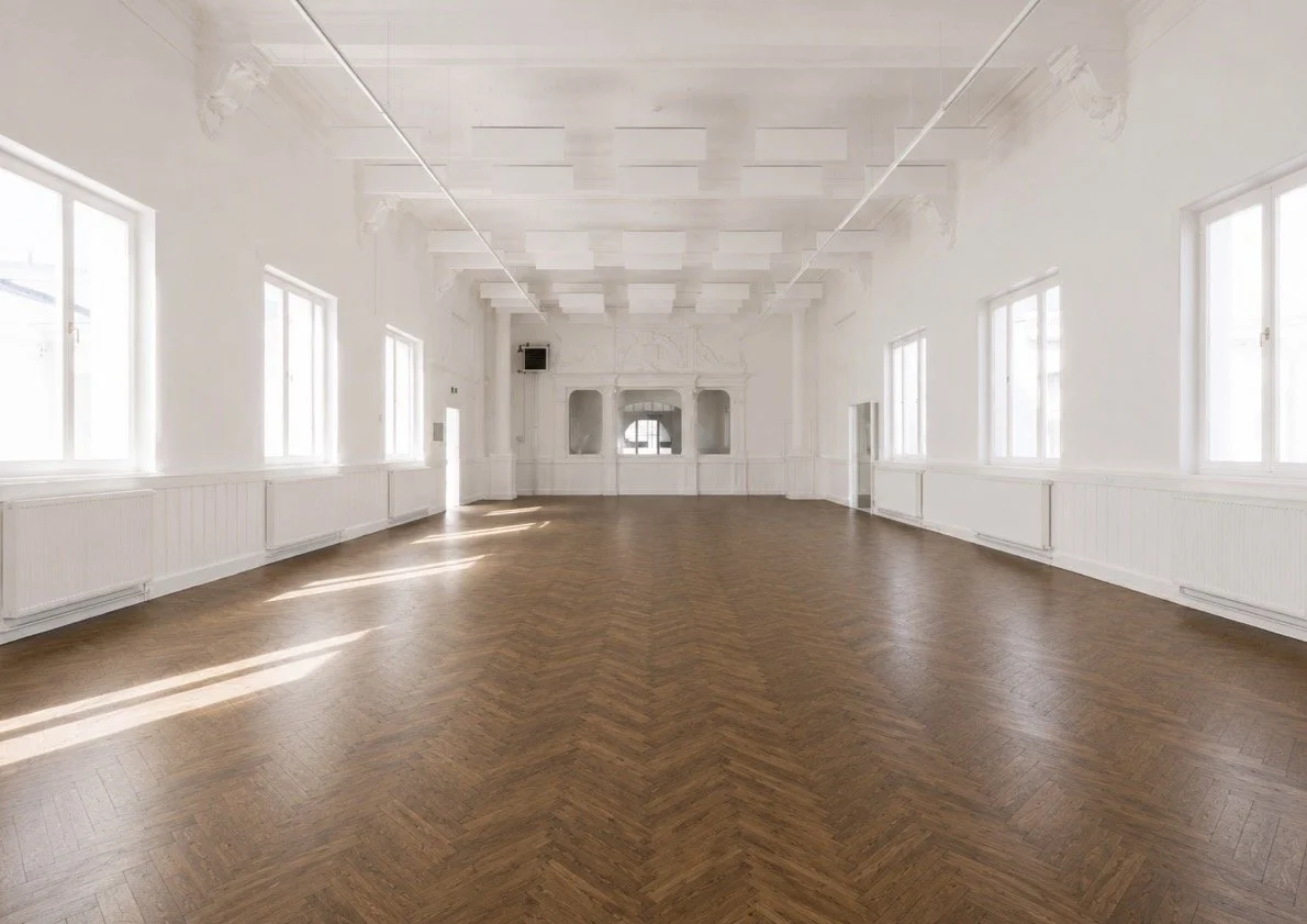 The large, light-filled central hall of the former commercial school on Schildersstraat in Antwerp, offering a spacious setting suitable for large groups.