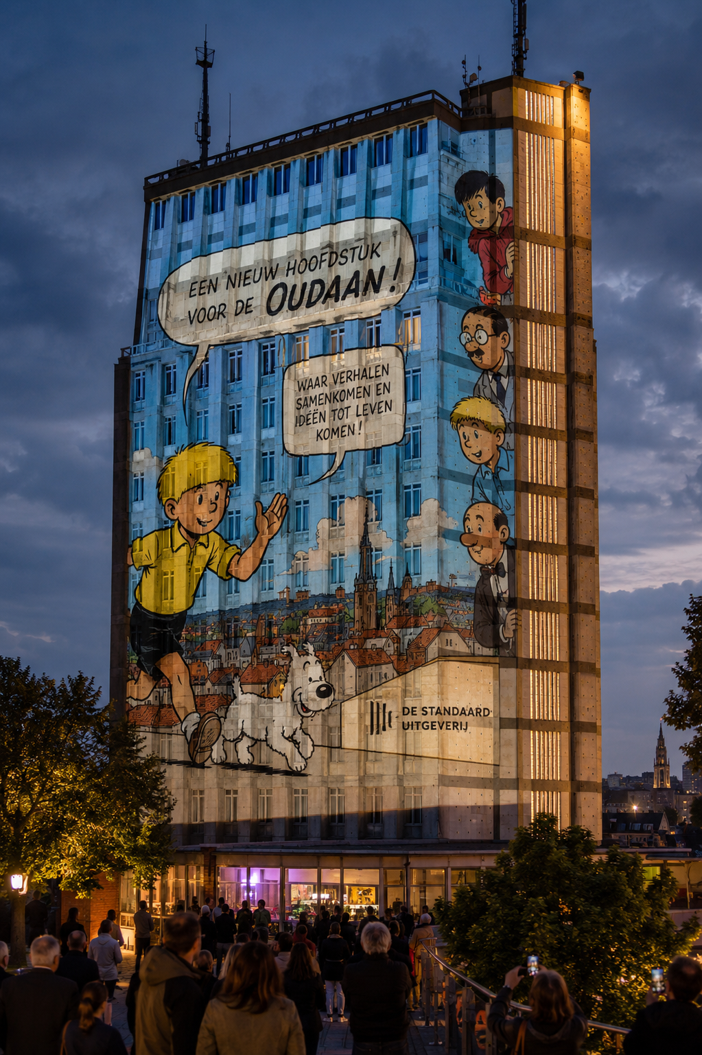 A tall building with a large mural of animated characters, including a boy with blonde hair and a dog, on its exterior. The mural promotes a new book for children with speech bubbles in Dutch. People are gathered at the base of the building, looking at the mural during early evening or twilight.
