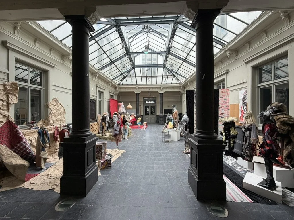 The bright, open interior of the historic former Handelsinstituut on Schildersstraat, featuring a glass ceiling that fills the space with natural light, a WAVE building in Antwerp.