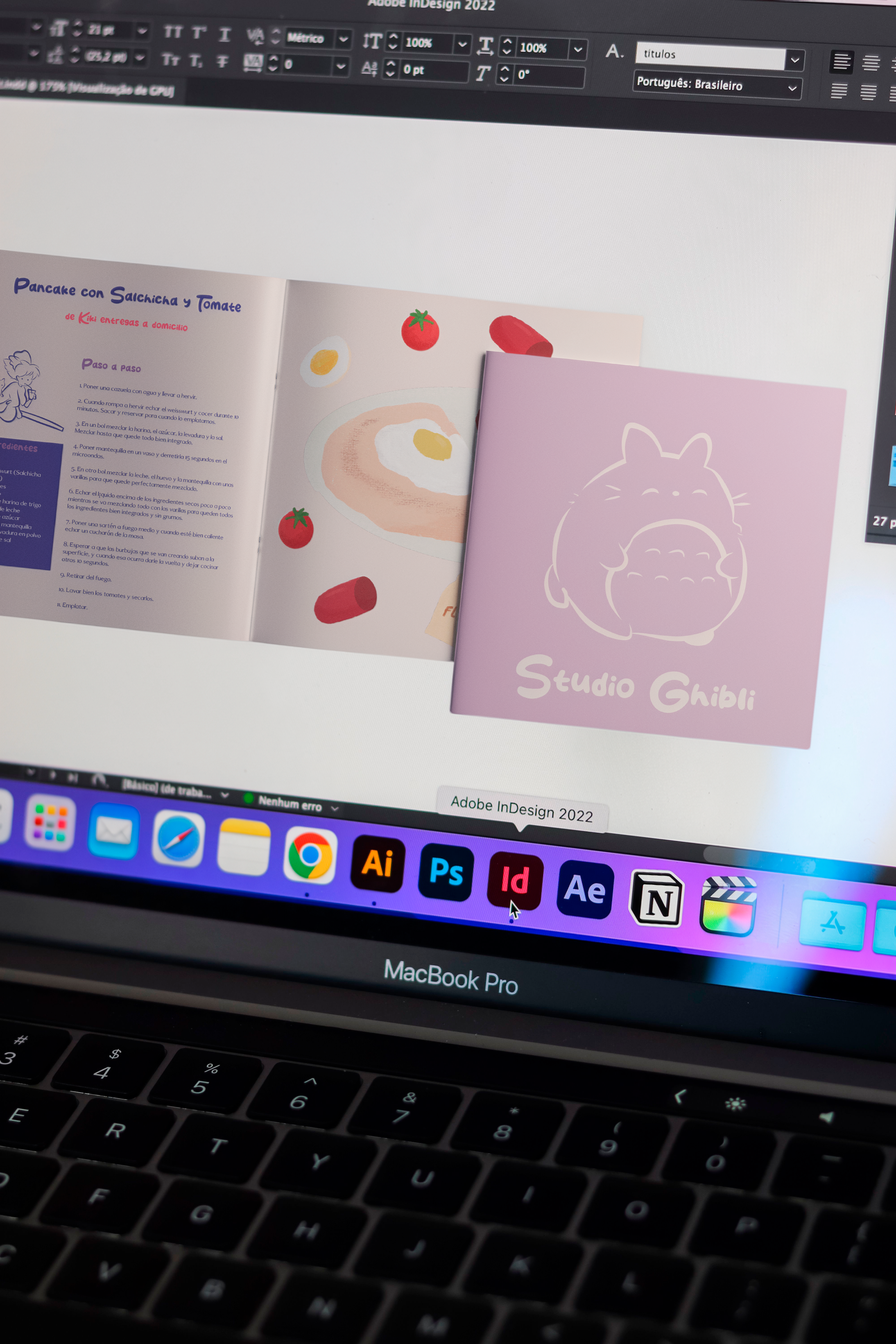 Pantalla de una laptop mostrando el programa Adobe InDesign y la barra de herramientas, con varios iconos y un documento abierto con instrucciones para preparar una receta de panqueques.