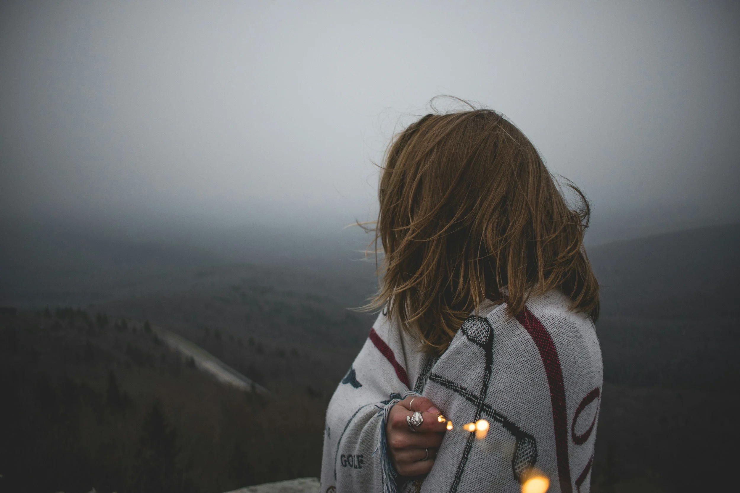 Person holding sparklers at dusk in a foggy landscape, symbolizing hope and resilience in brain injury, brain tumor, and trauma counseling for survivors, caregivers, and healthcare professionals in Connecticut