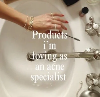 A person's hand with jewelry reaching over a bathroom sink, with the text 'Products I’m loving as an acne specialist' overlayed on the image.