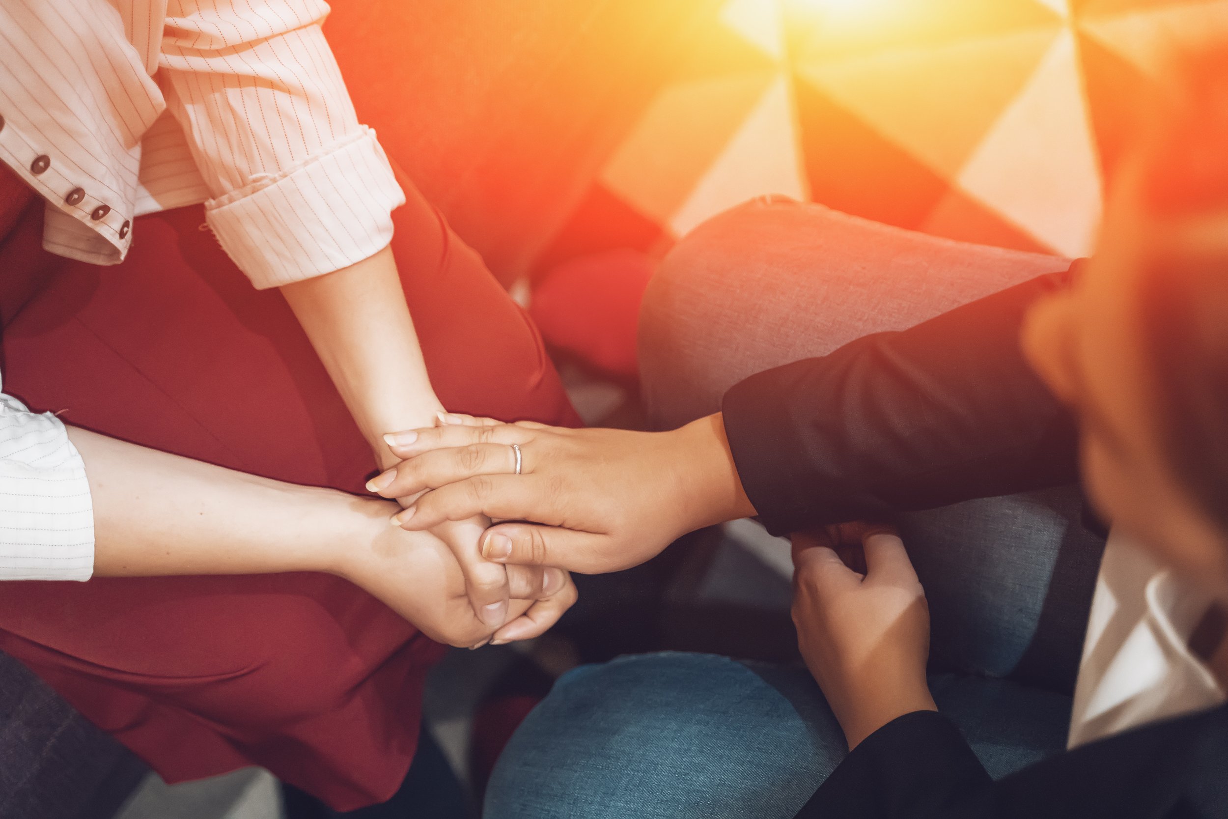 Multiple people holding hands in a group,
