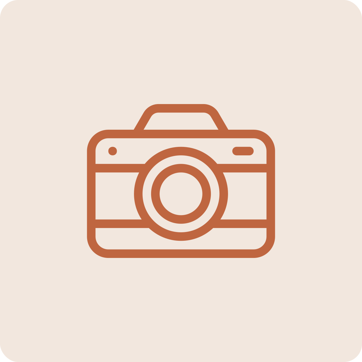 Icon of a camera in brown outline on a light background.