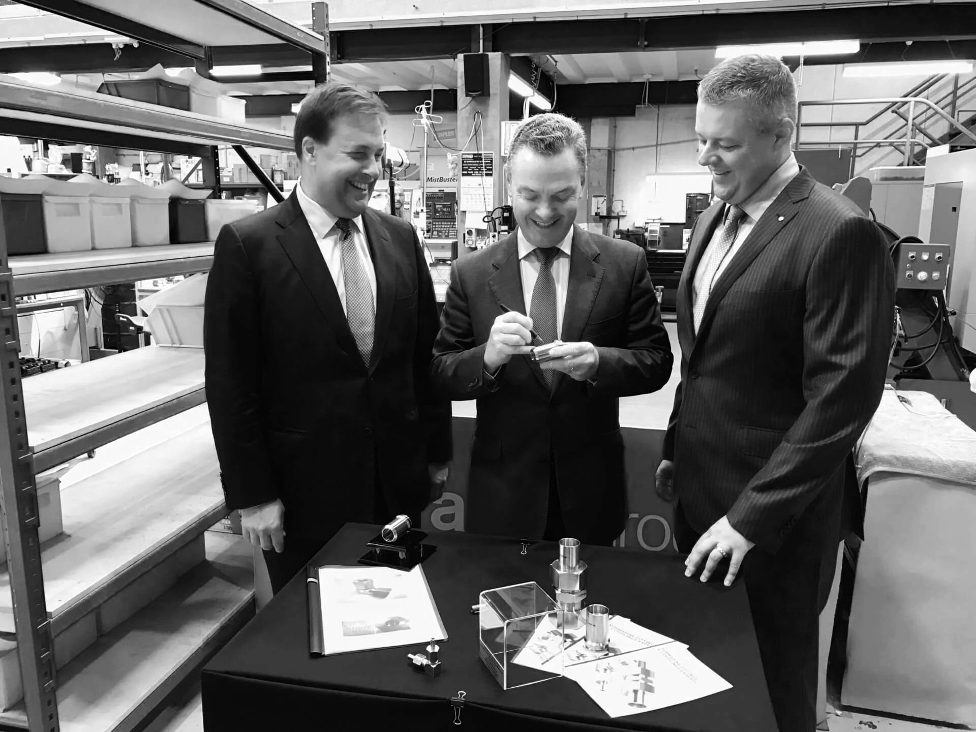 Wiliams Advisory with the Hon. Christopher Pyne on the H.I. Fraser factory floor gathered around a table, examining metal parts.