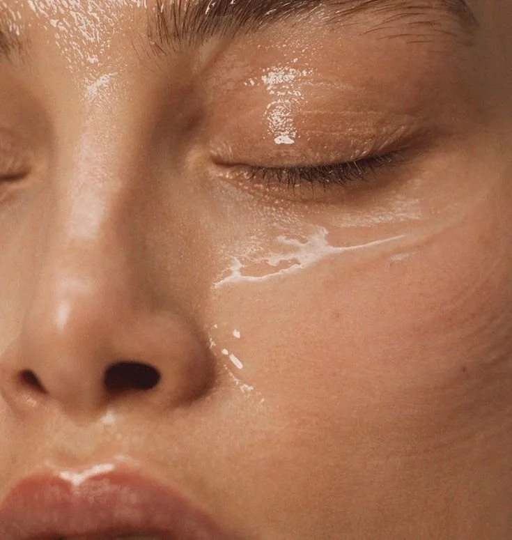 Close-up of a person's face with closed eyes, showing a tear running down the cheek.