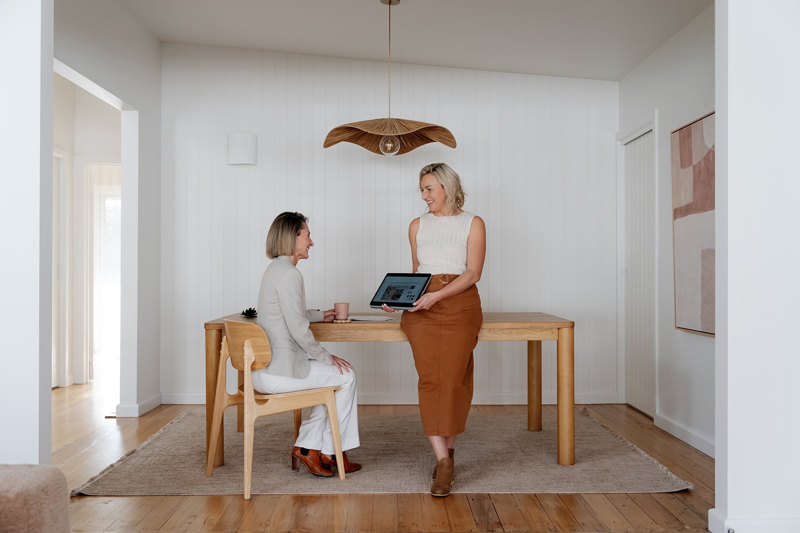 Gemma and Client talking at desk looking at strategy document on ipad
