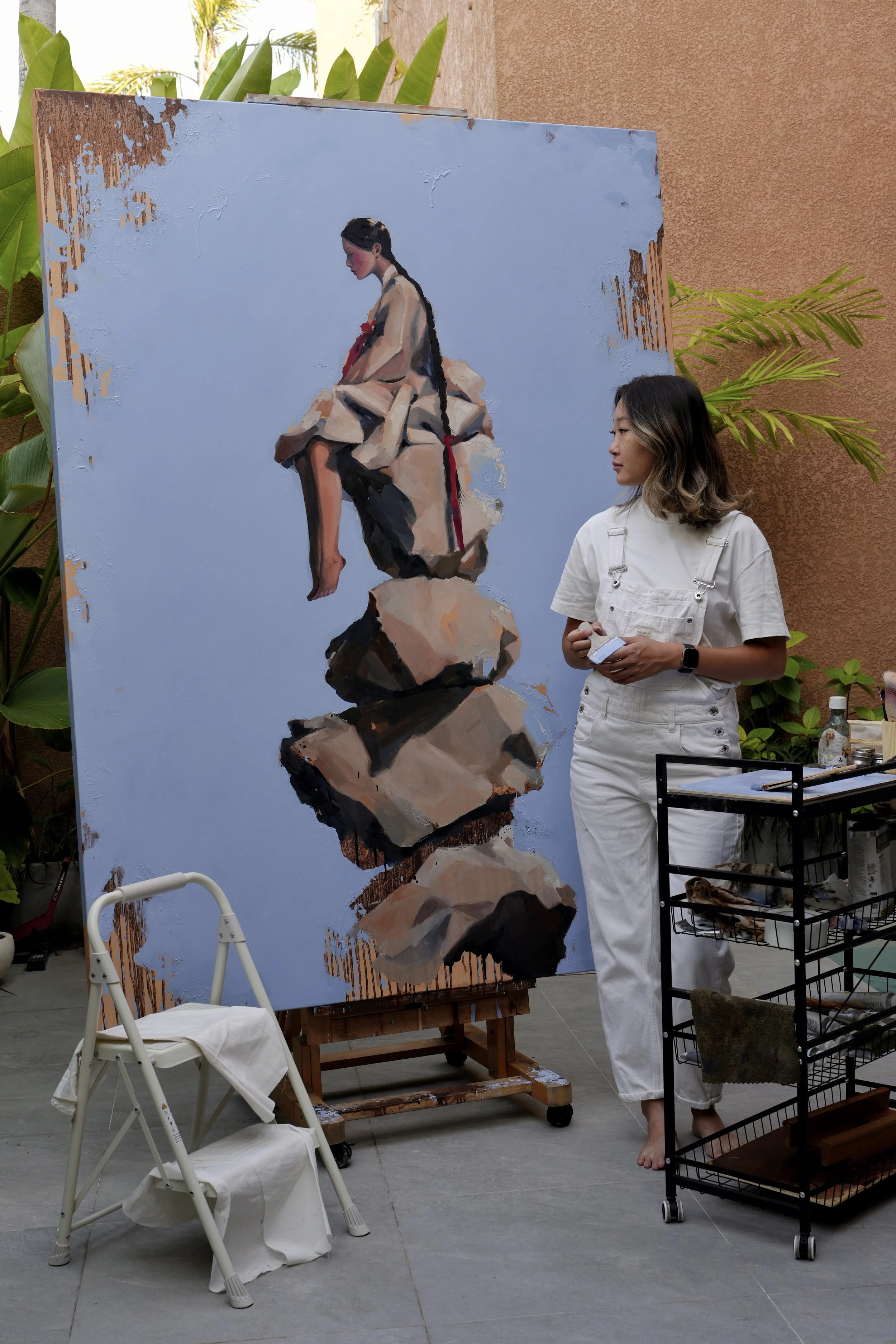 Marina Ogai standing beside Cairn in her studio, showing the scale of the 200 × 150 cm canvas
