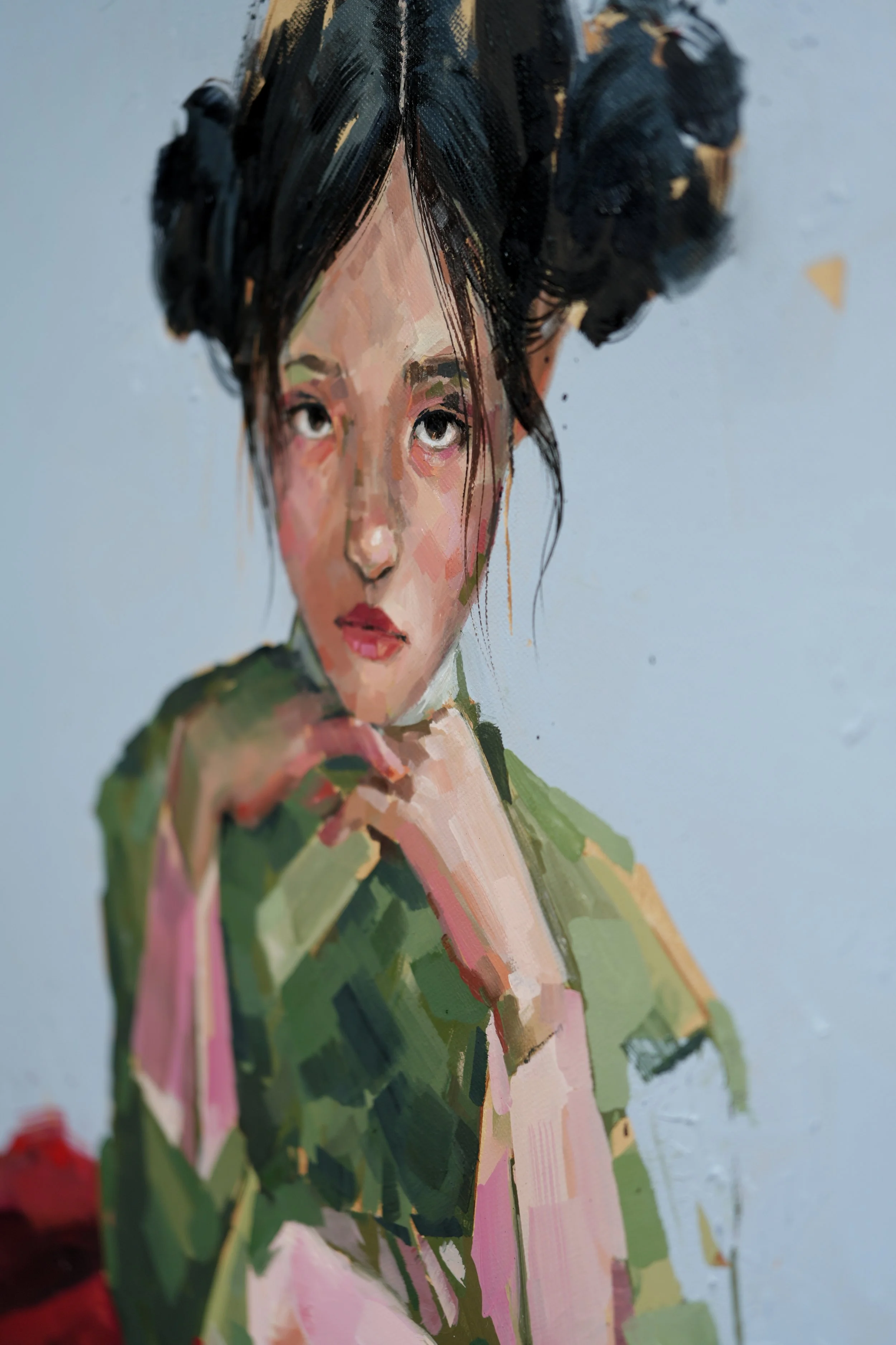A young girl rests her hands near her chin with a sombre sidelong look, black hair in buns, close oil detail, from Given by Marina Ogai