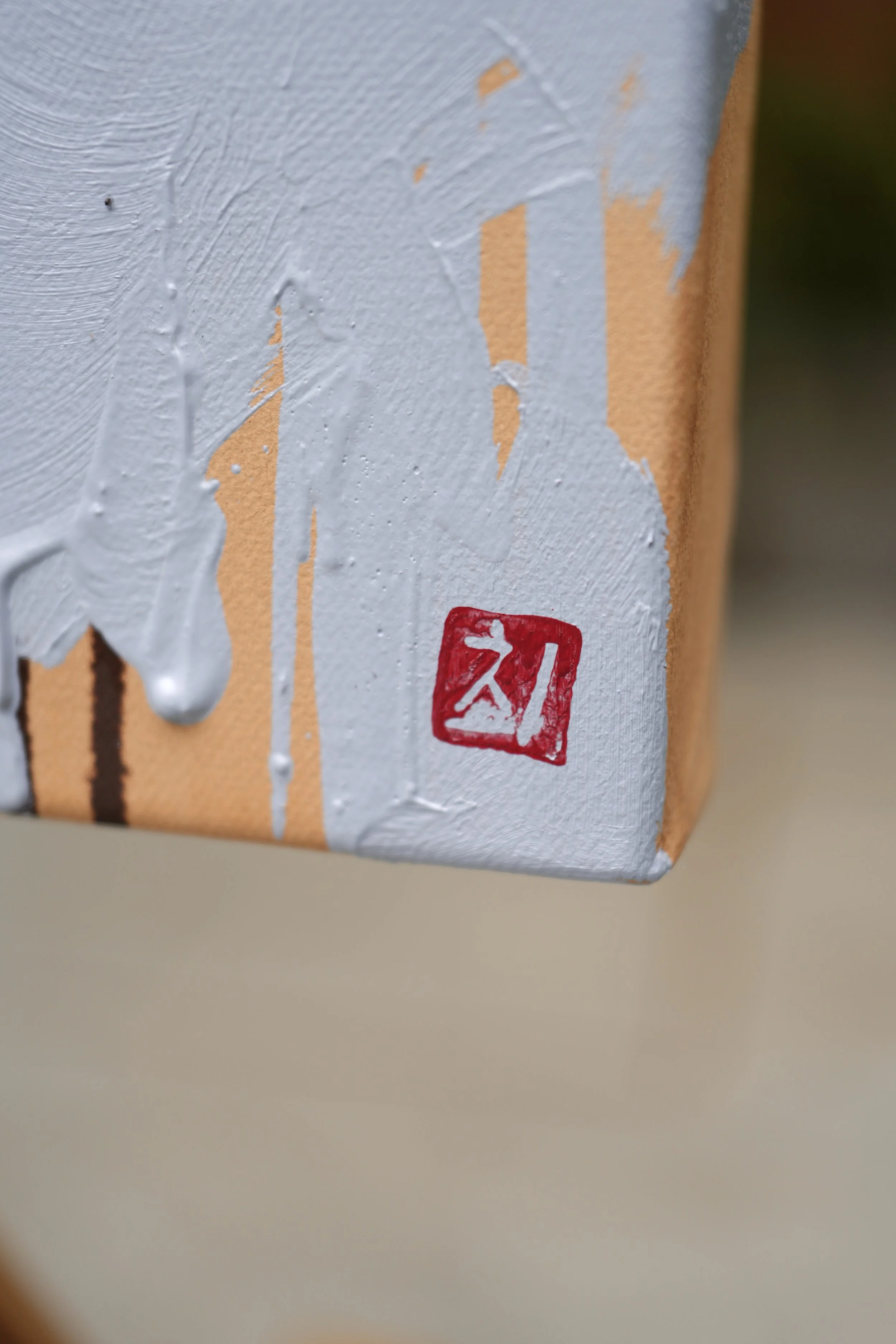 Painted canvas edge with a red seal signature – side detail of The Aftermath by Marina Ogai